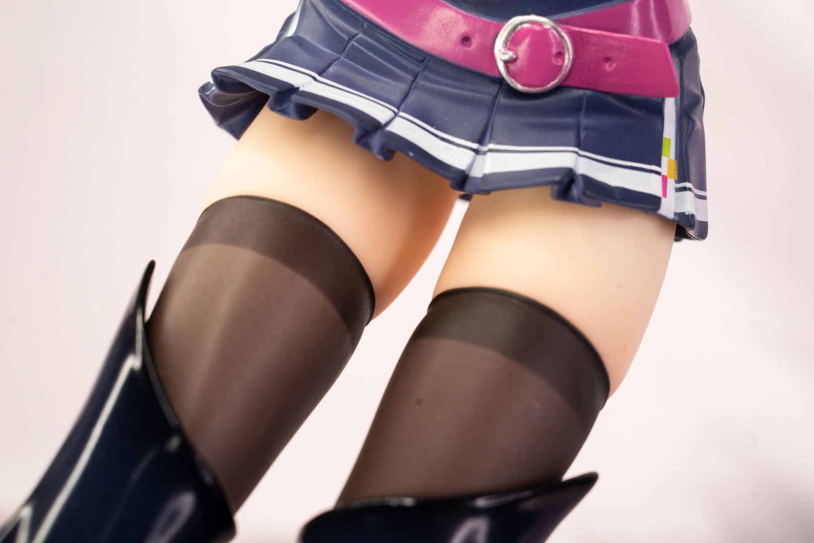 スカートの紺とニーハイソックスの黒に挟まれた絶対領域のコントラストがまぶしい。ベルトのピンクもワンポイントして効果抜群