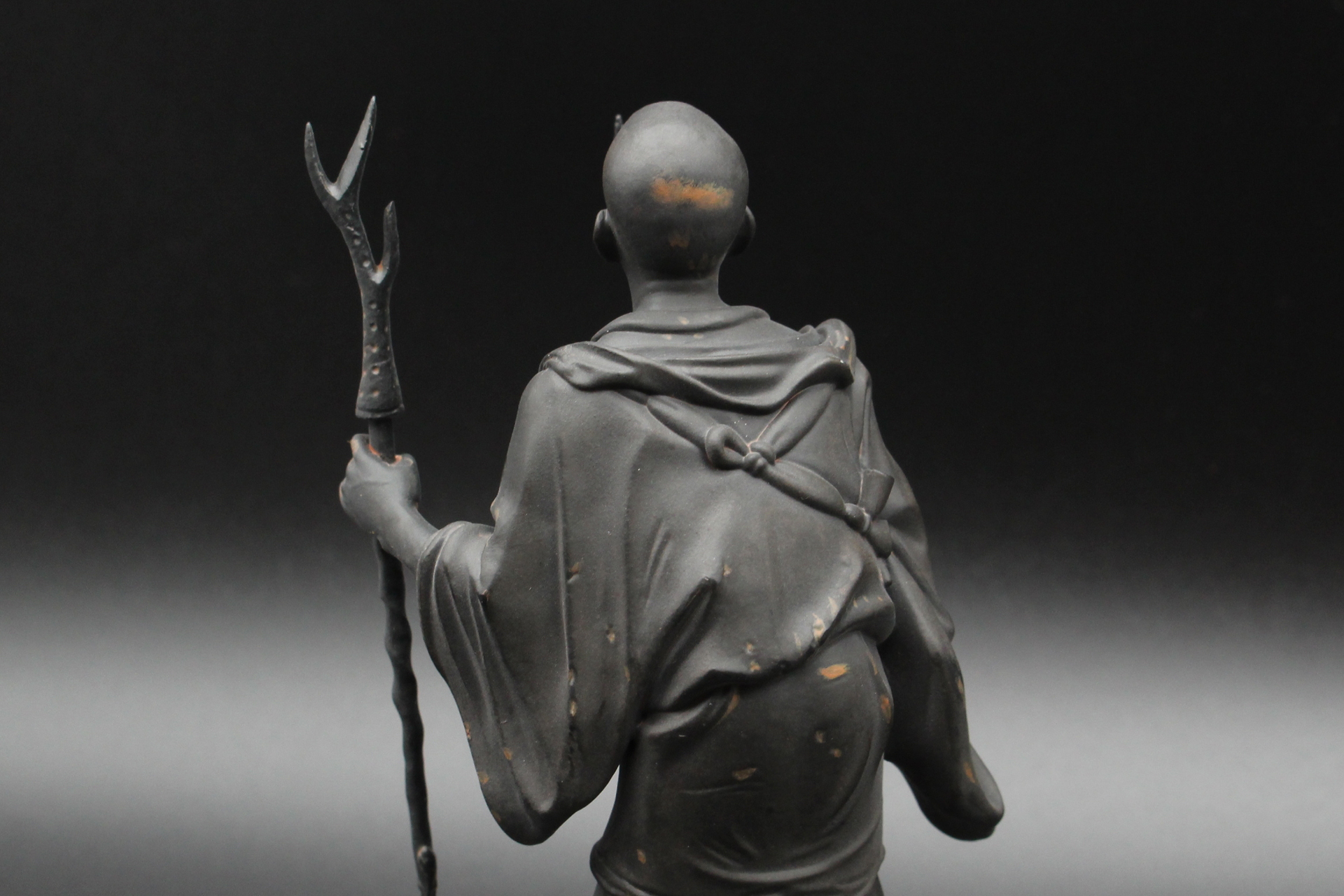 衣の首の後ろには、フードのようなものが見える