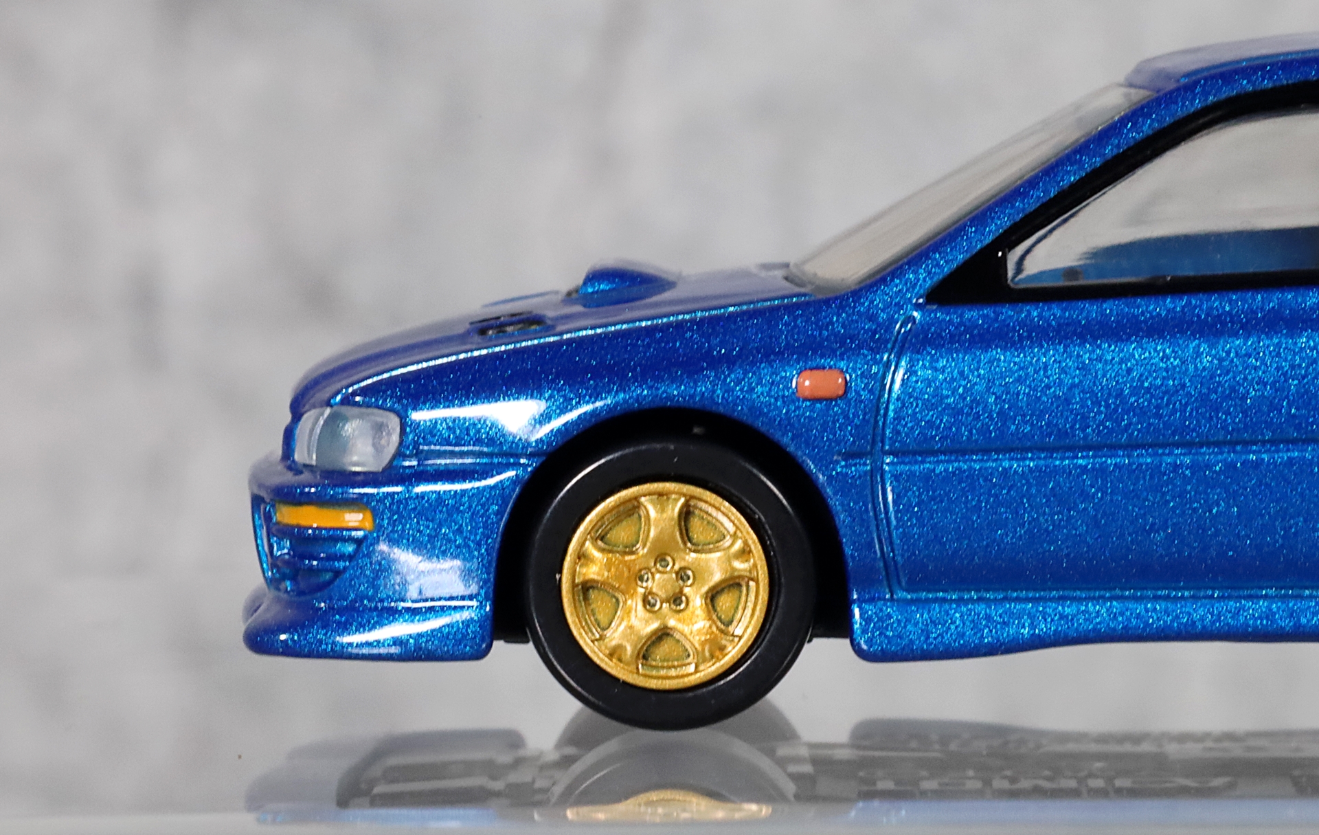 青いボディと絶妙にマッチするゴールドのホイール。“スバルブルー”にイエローの“六連星”を施したワークスカラーを彷彿とさせる