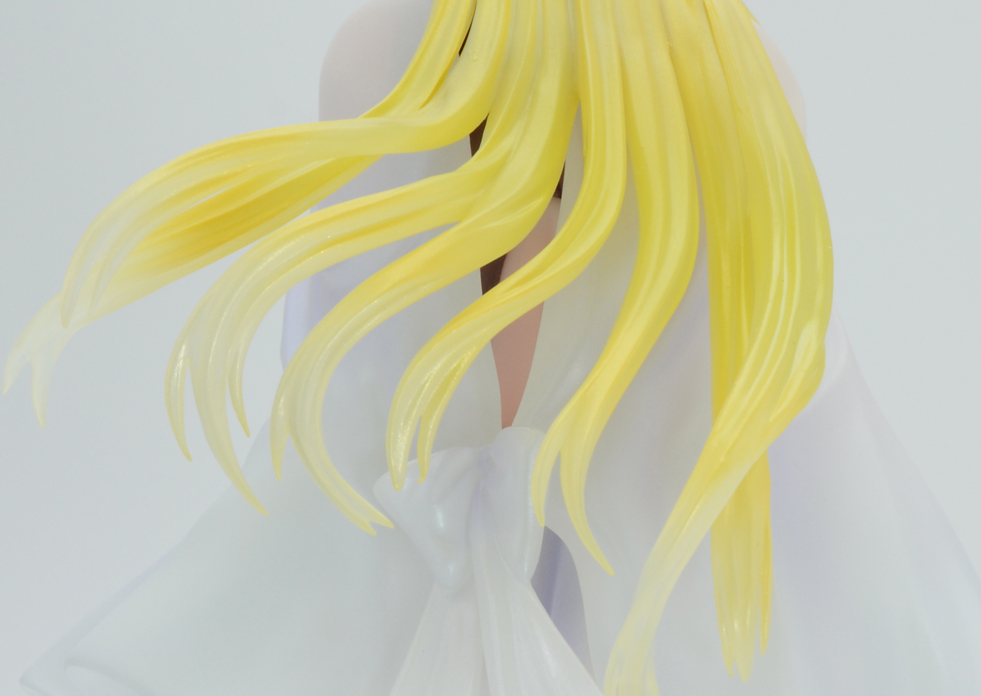 マントと金髪の間から背中が見える