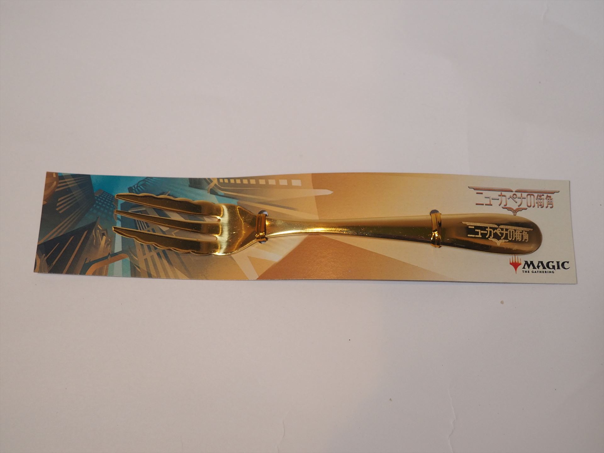 金色のフォークも1本入っていた。持ち手の部分に「ニューカペナの街角」の文字が入っている