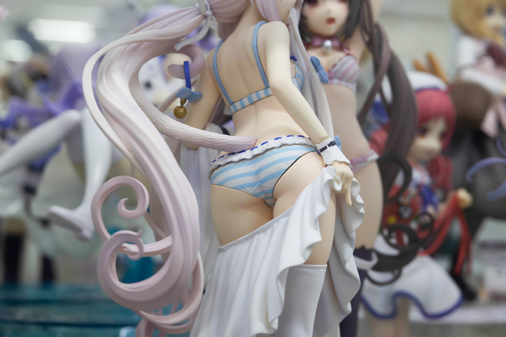 渦を巻くように長いバニラの髪。尻尾の先には、首輪の鈴が付けられている。