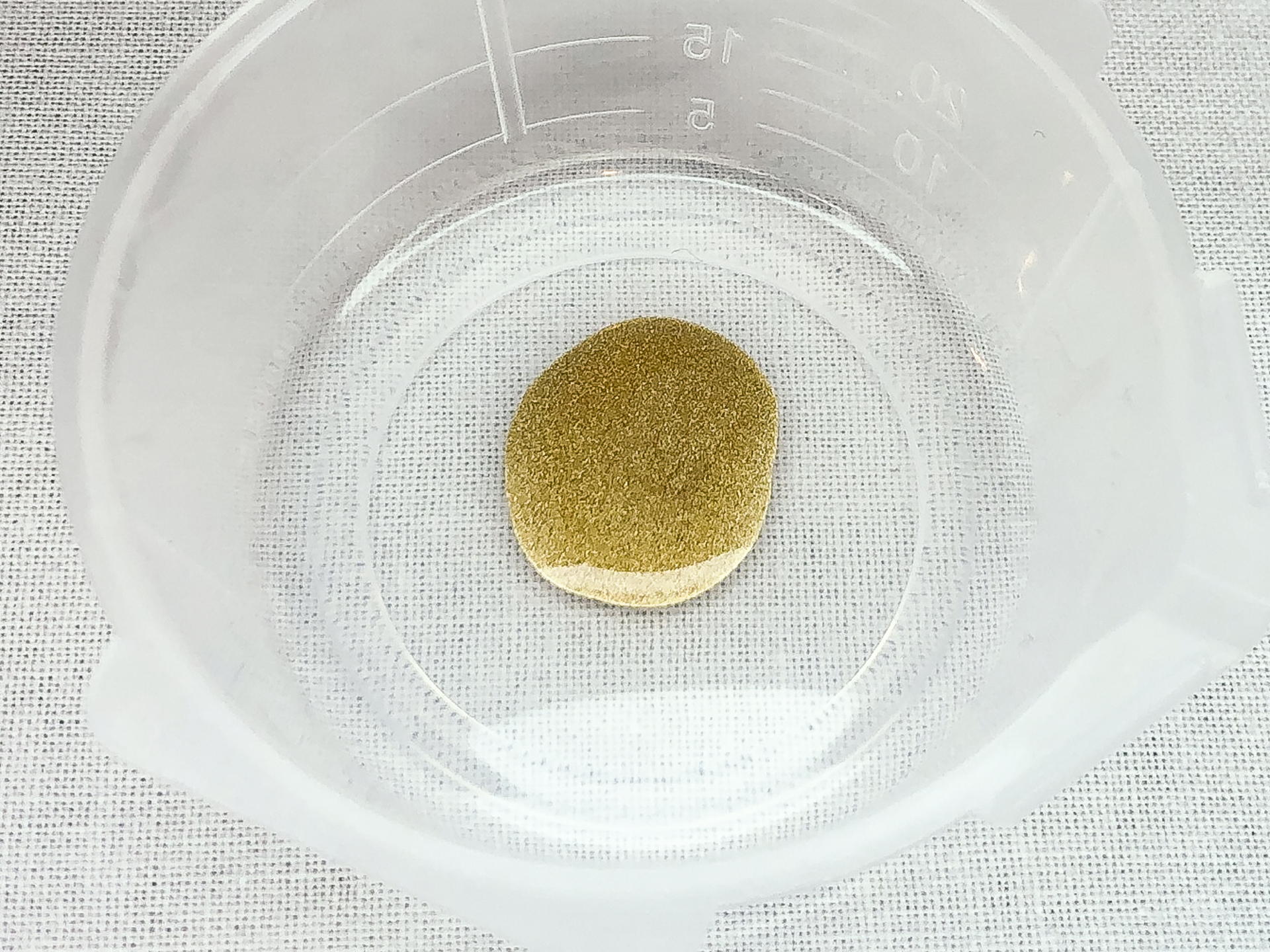 塗料皿に出した「GSIクレオス ガンダムマーカーEX ホワイトゴールド」のインク。このインクを筆につけて筆塗を行ないます。色味は筆塗やガンダムマーカーエアブラシシステムで塗装した場合と近い色味となっています。