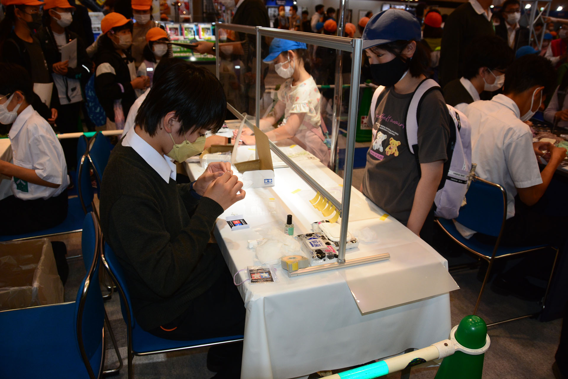 タミヤのブースでは高校生ボランティアが子供たちのサポートをする