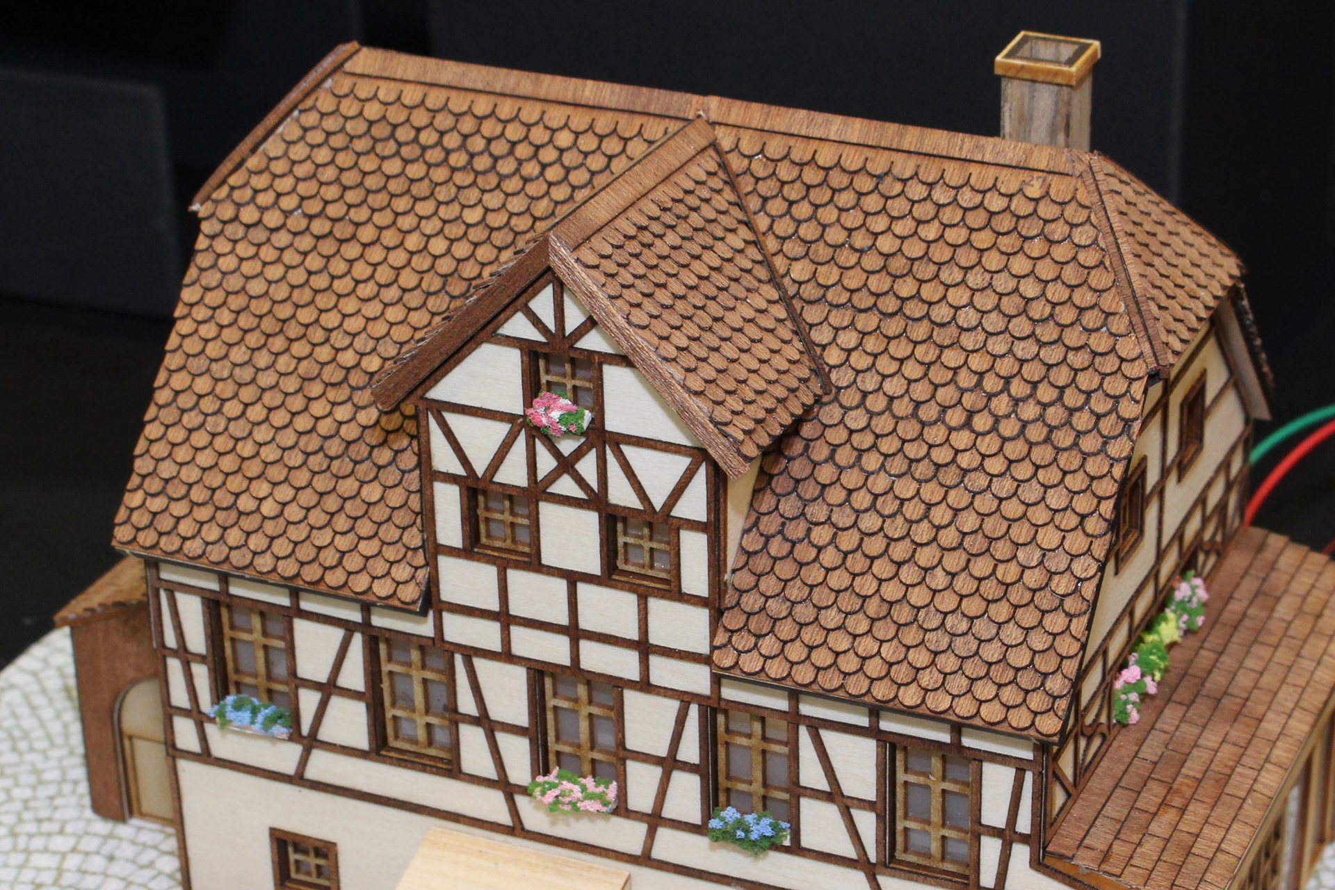 木の素材を生かした家屋。屋根はレーザーカッターで波形にカットされたパーツを貼り合わせている