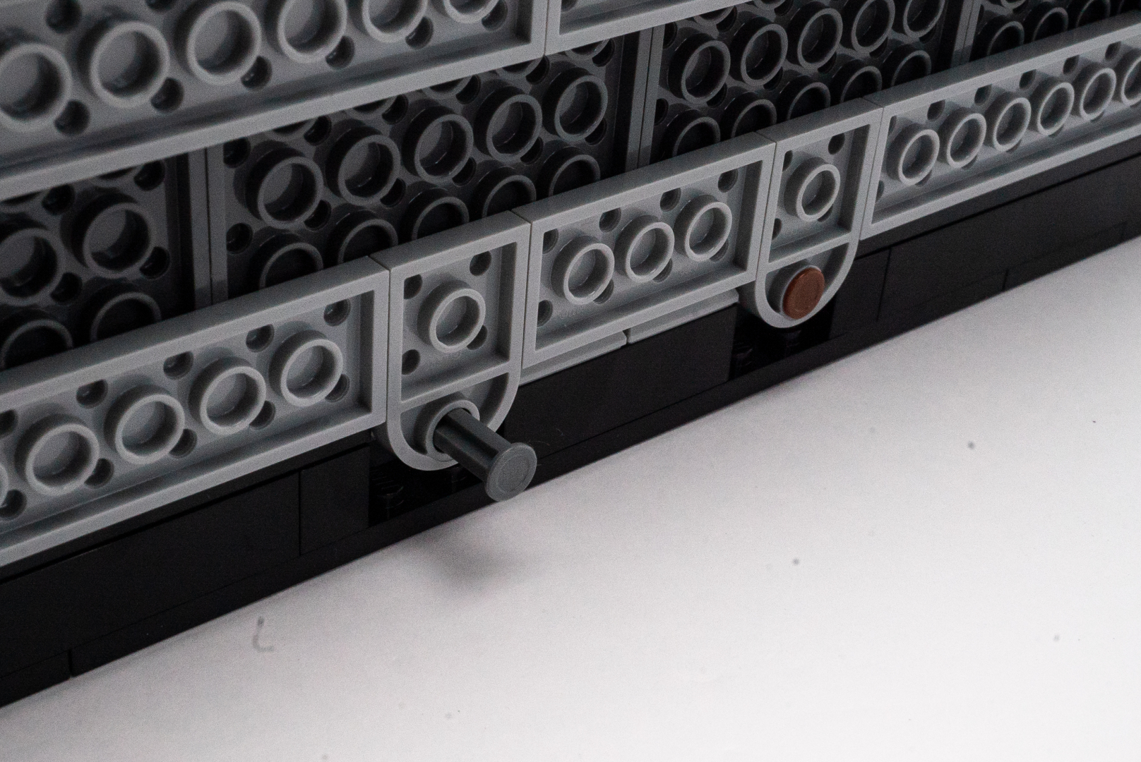 壁の穴の空いた部分とベースの十字の穴を使って、アクスルと呼ばれる棒状のテクニック系パーツで接続する