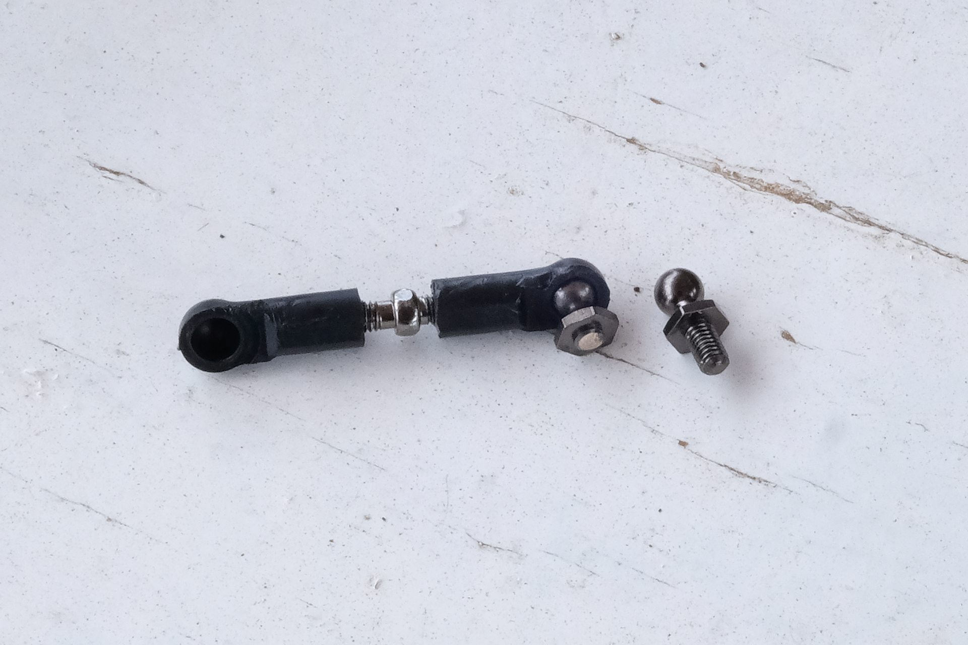 右は予備のピローボール。左のシャフトに付いているピローボールが折れてしまっている