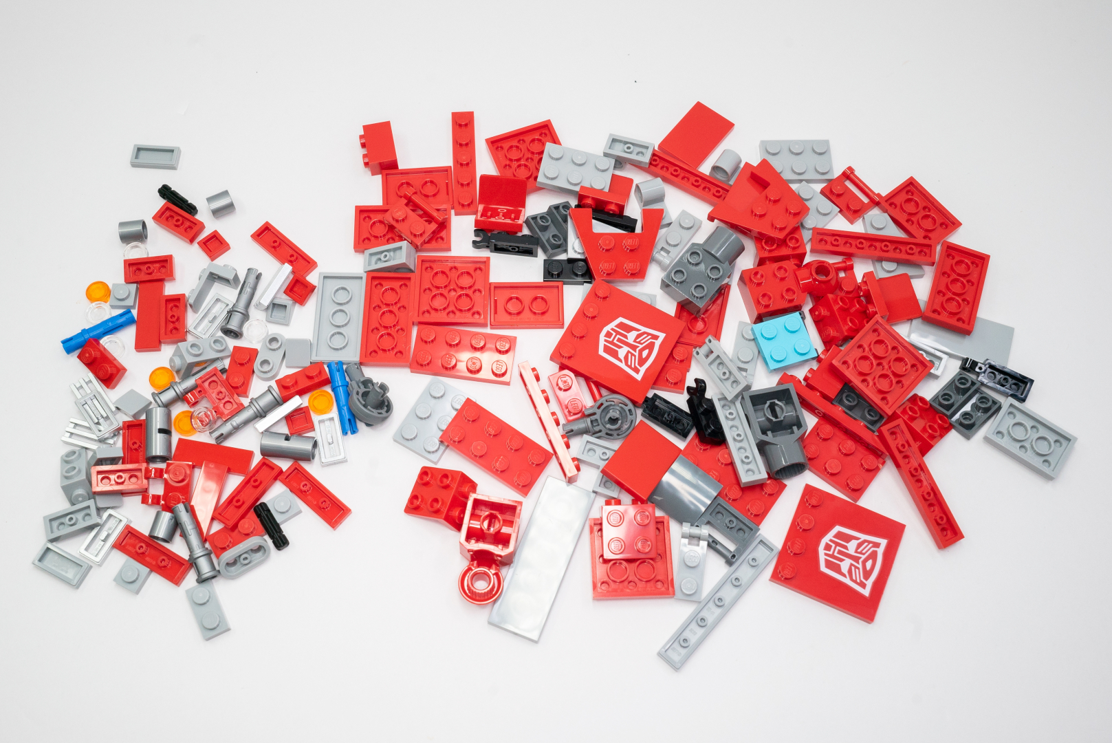 袋7のパーツ構成は。再び赤色中心。これでフロント部分や肩を組んでいくのだ。サイバトロンのマークがプリントされたパーツも嬉しい