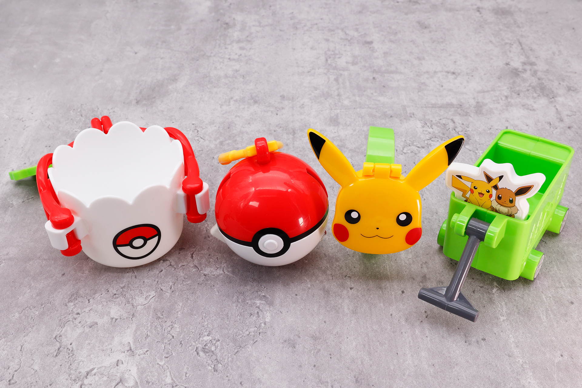 こちらが第2弾（6月24日～6月30日）のハッピーセット「ポケモン アウトドア」に登場するおもちゃ。写真左から「ポケモン キャンプマグ」、「モンスターボール 探検ツール」、「ピカチュウ コンパス」、「ポケモン キャンピングワゴン」