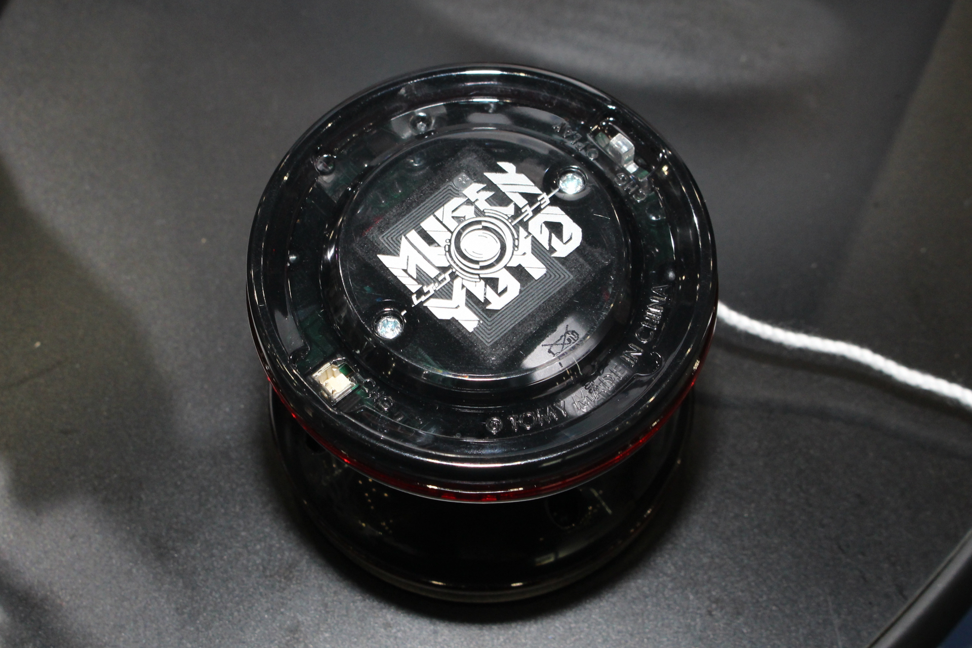 MUGENYOYO本体。左下の白い四角が充電端子、右上が電源スイッチ。中央にはNFCタグ