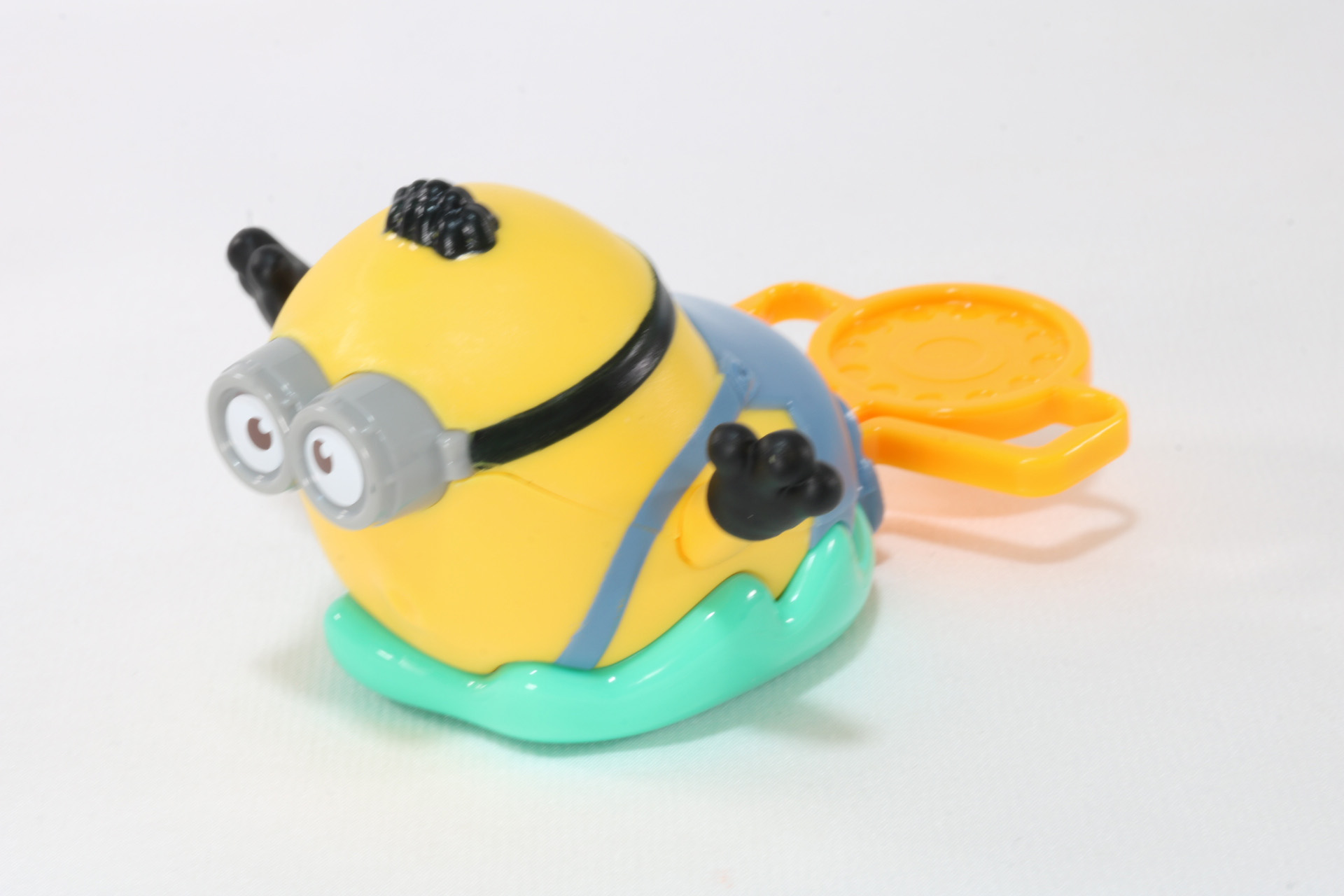 オレンジ色のクリップをオットーの靴に差し込み、クリップの両端をつまむことで勢いよく飛び出す仕掛けとなっている