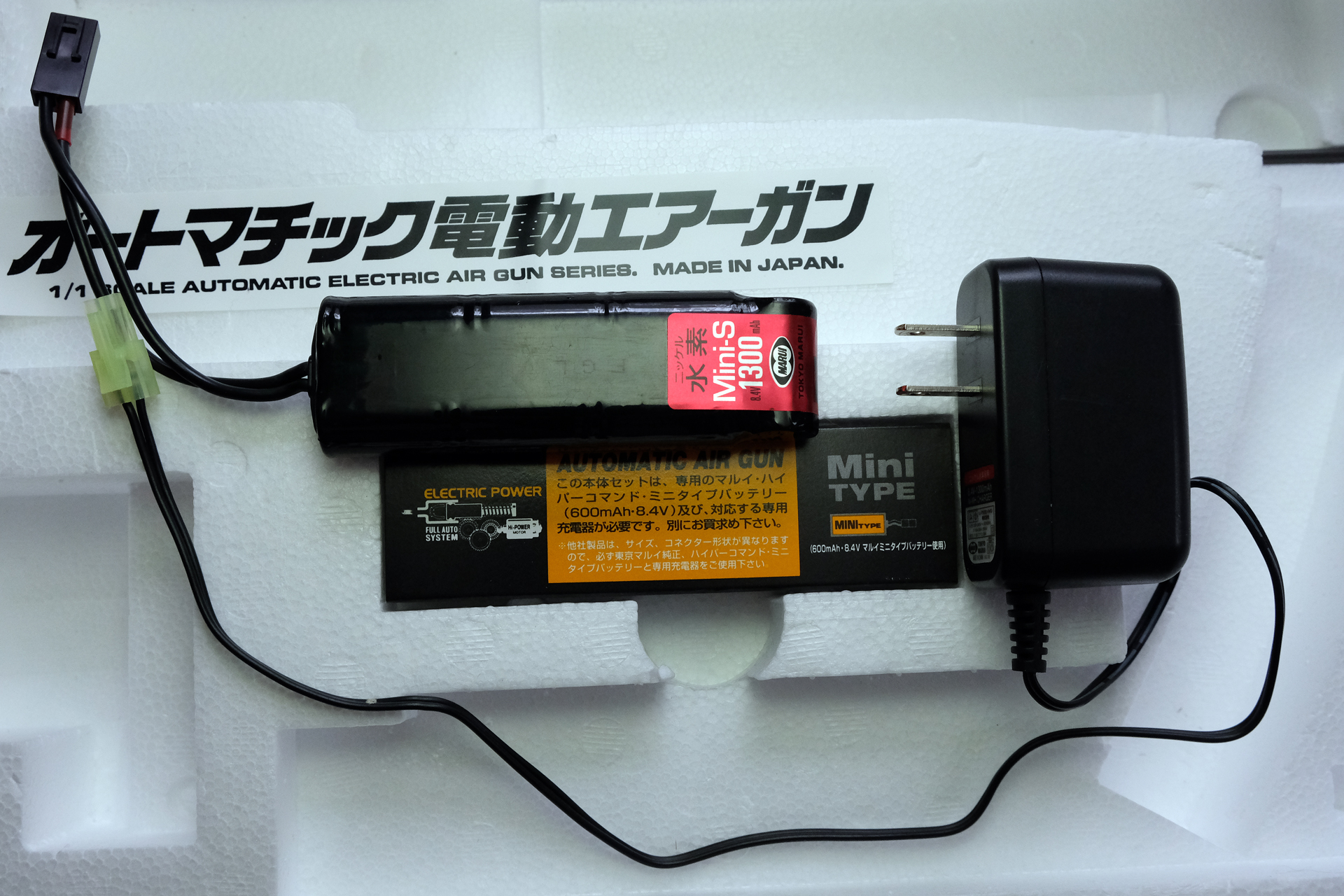 「電動ガンスタンダードタイプ H&K MP5A5 HG」に使用する、「8.4Vニッケル水素1300mAhミニSバッテリー」と「NEW 8.4Vニッケル水素専用 充電器」。東京マルイ純正品は安心安全に、繰り返し長く使える