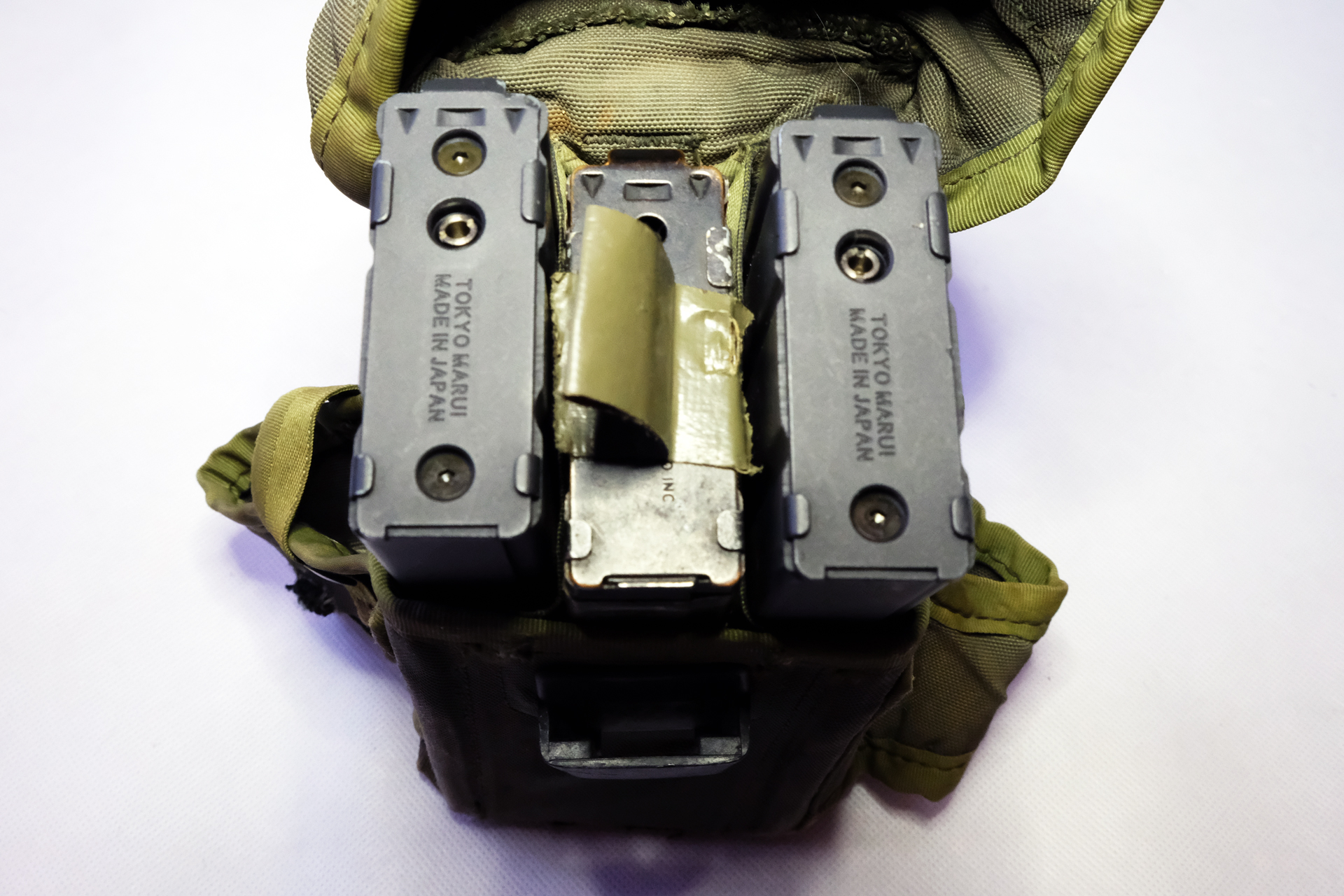 米軍の実物マガジンパウチに入れたガスブローバックマシンガン用マガジン2本。真ん中が電動ガンスタンダードタイプのM16用。電動の物は若干厚みがある。実物のマガジンパウチだとキツくなる理由が30年越しで腑に落ちた