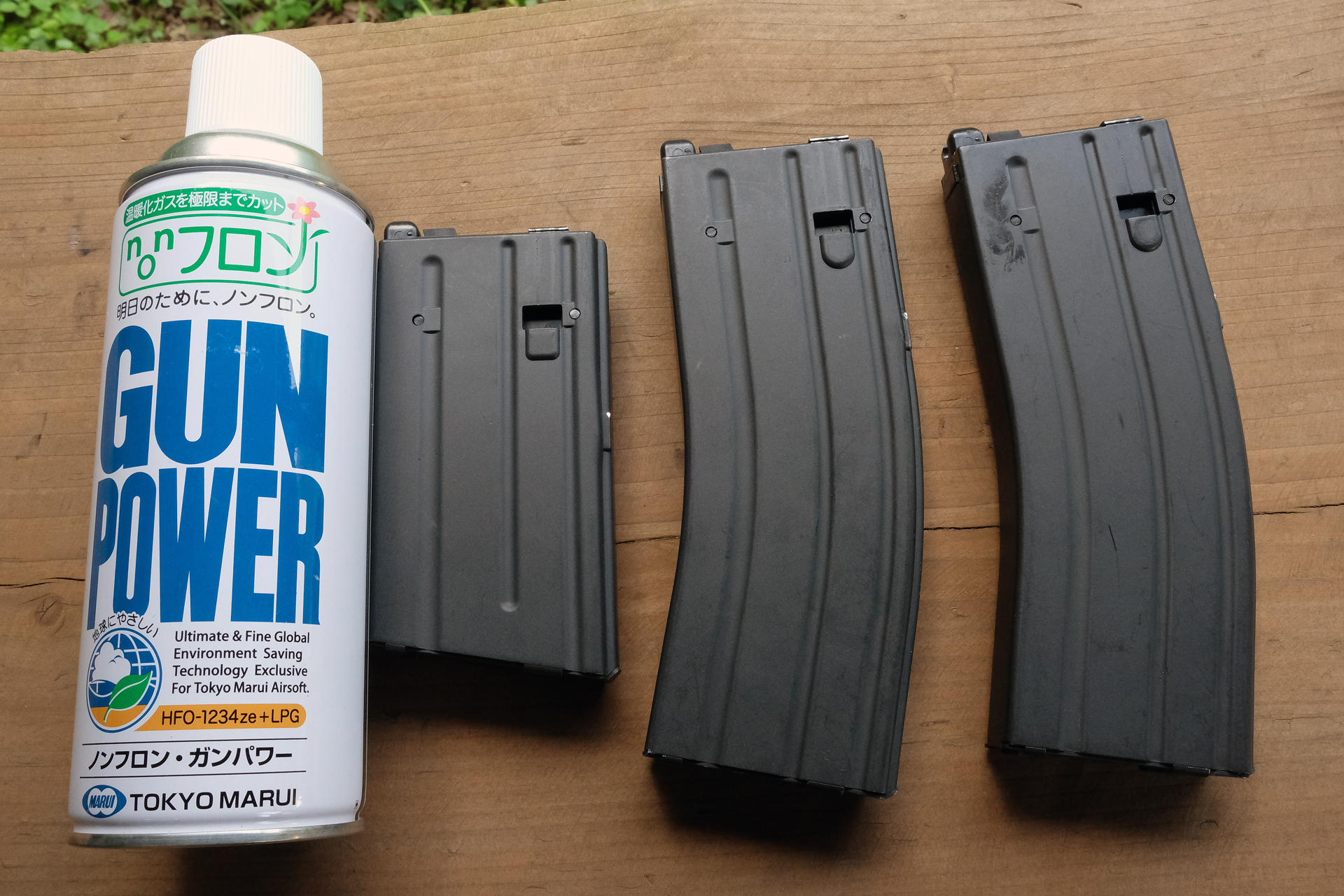 ガスブローバックマシンガンのマガジンとノンフロン・ガンパワー。ノンフロンは従来品より冷えに強く、ガス圧が1割ほど抑えられる。夏場にはパワーを抑える効果がある