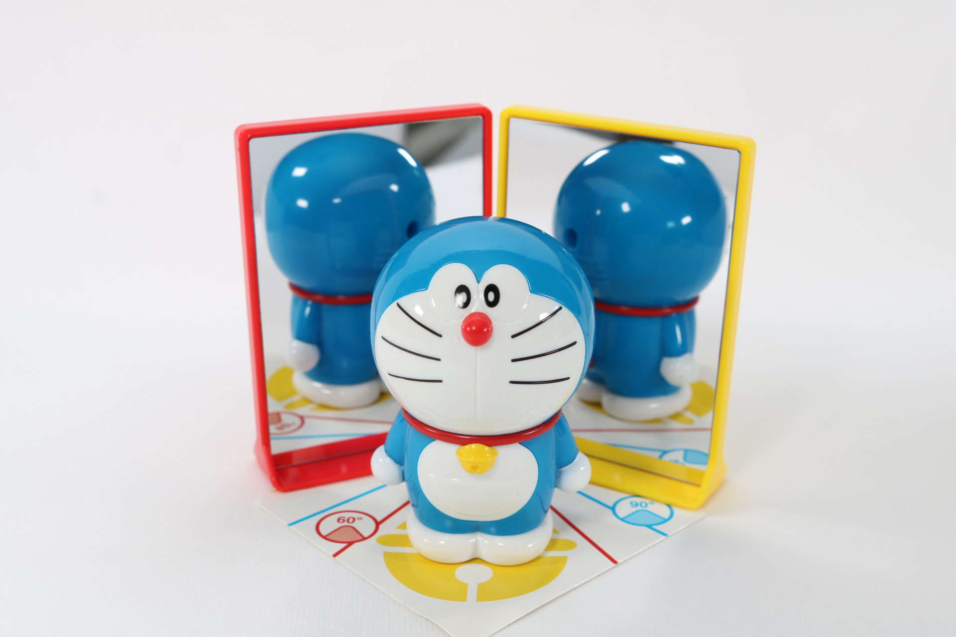 台紙に書かれている線に合わせて鏡を配置し、鈴のイラストにドラえもんを乗せると鏡にドラえもんの姿が映る