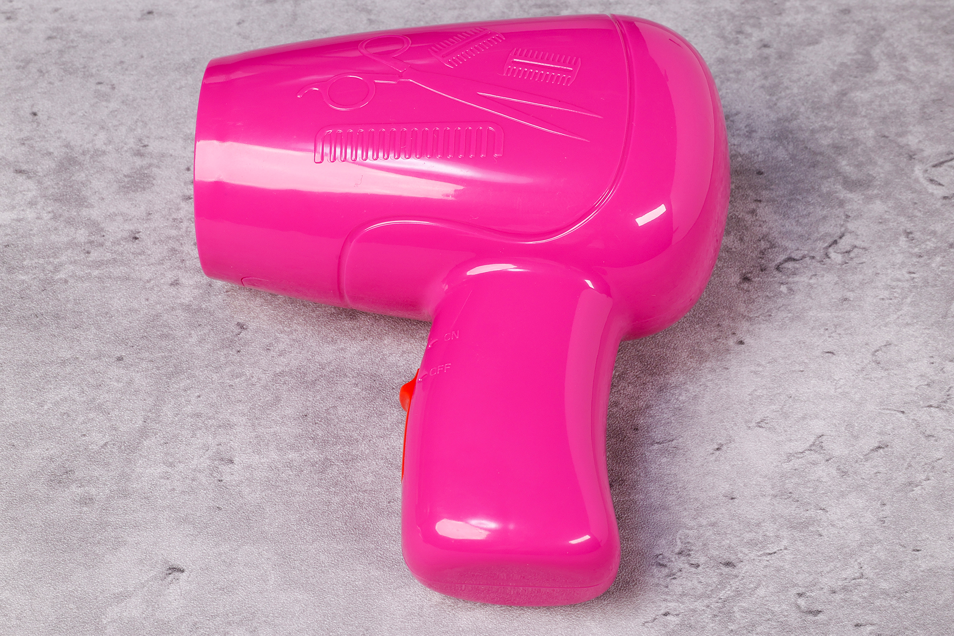 こちらはドライヤー。くしやハサミなど、美容師の道具が刻印されている