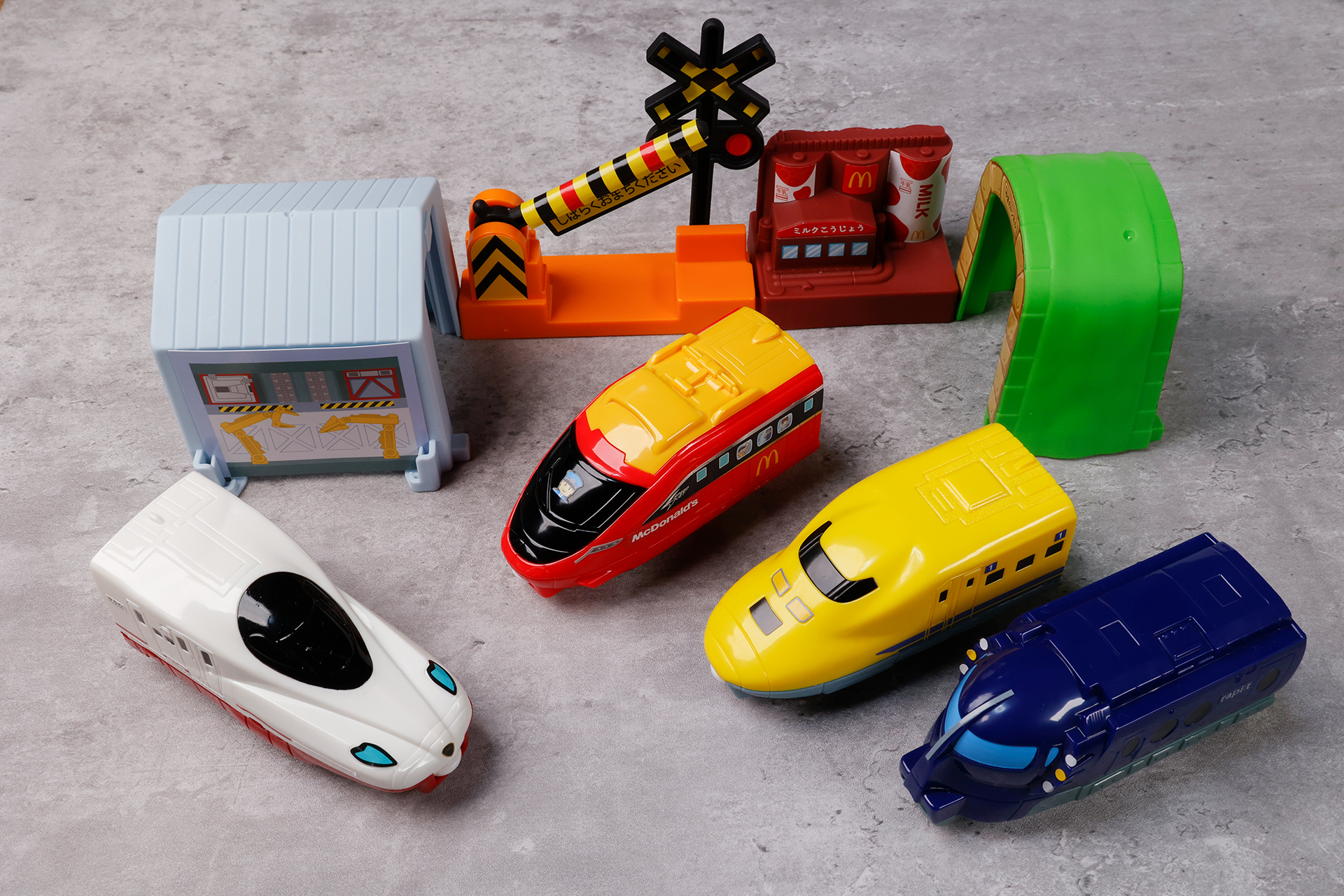 こちらが第1弾（9月30日～10月13日）のハッピーセット「プラレール」に登場するおもちゃ。写真左から「西九州新幹線N700Sかもめ＆ミルク工場」、「スピードジェットスペシャルカラー（マクドナルド）＆やまのトンネル」、「923形ドクターイエロー＆車両工場」、「南海ラピート＆踏切」