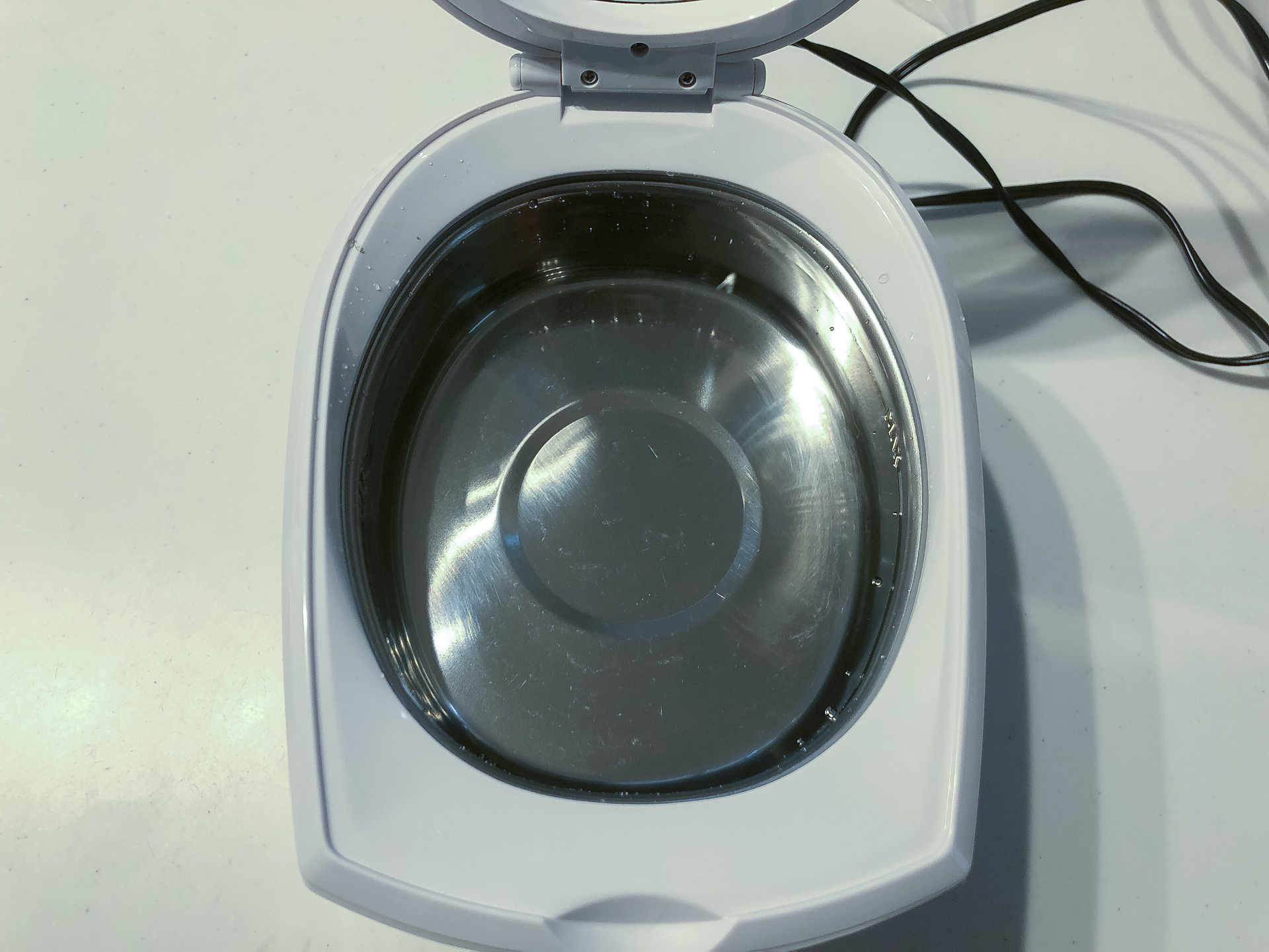 洗浄前の超音波洗浄機。中に入れた水は澄んでいます。