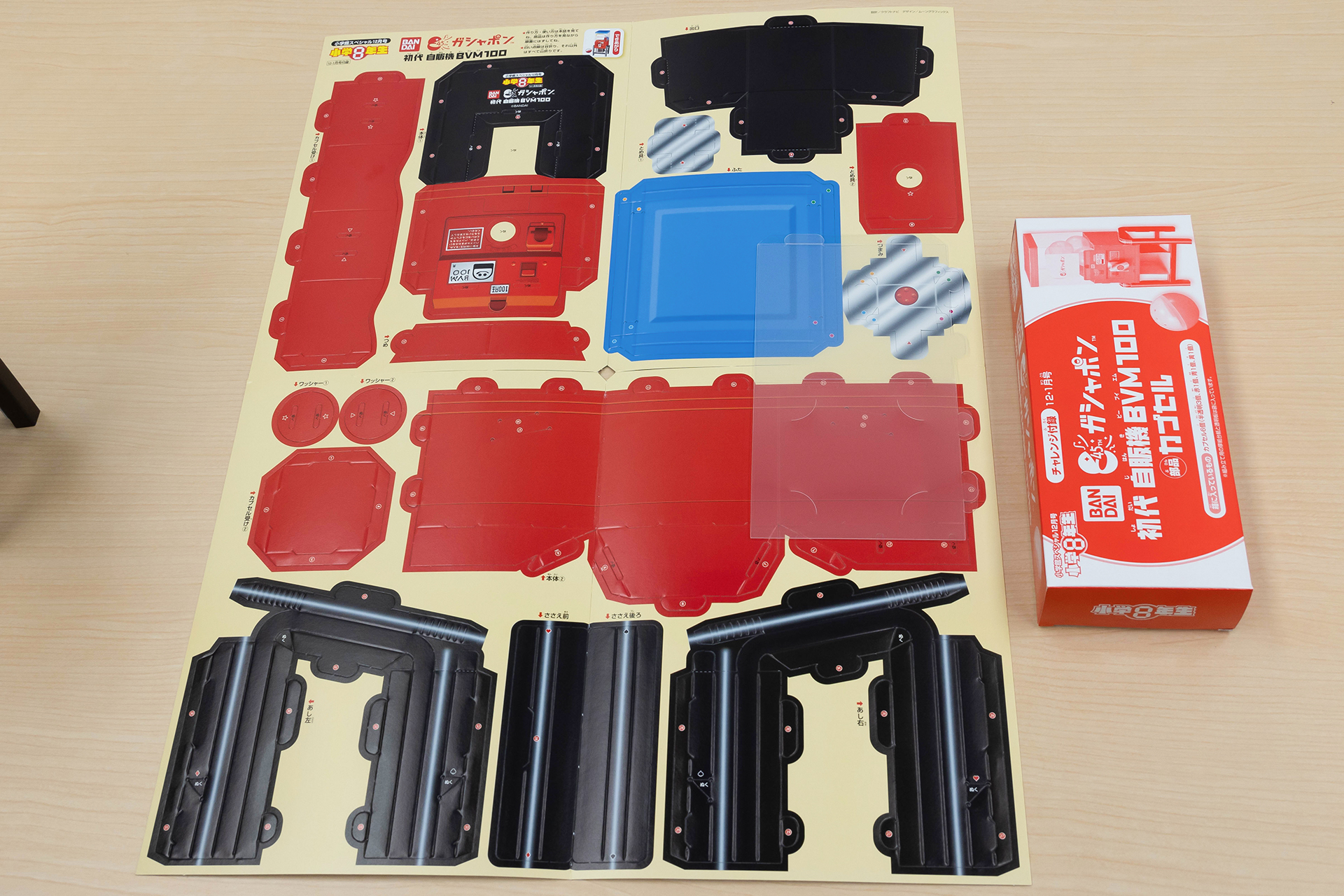 組み立てる前のペーパークラフト。箱に入っているのは、ガシャポンのカプセルだ