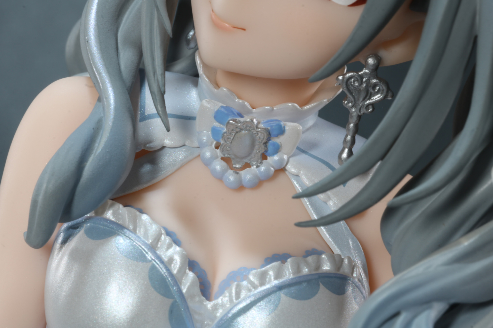 首のブローチ、イヤリングはメタリックな質感表現がされている