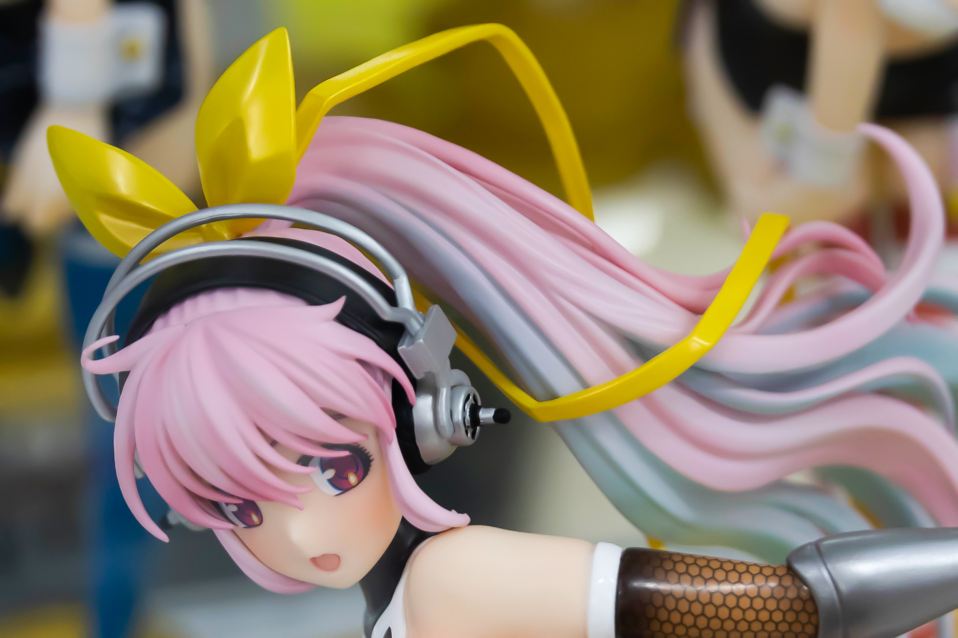 頭には黄色いリボンと大きなヘッドフォンを身に付けている