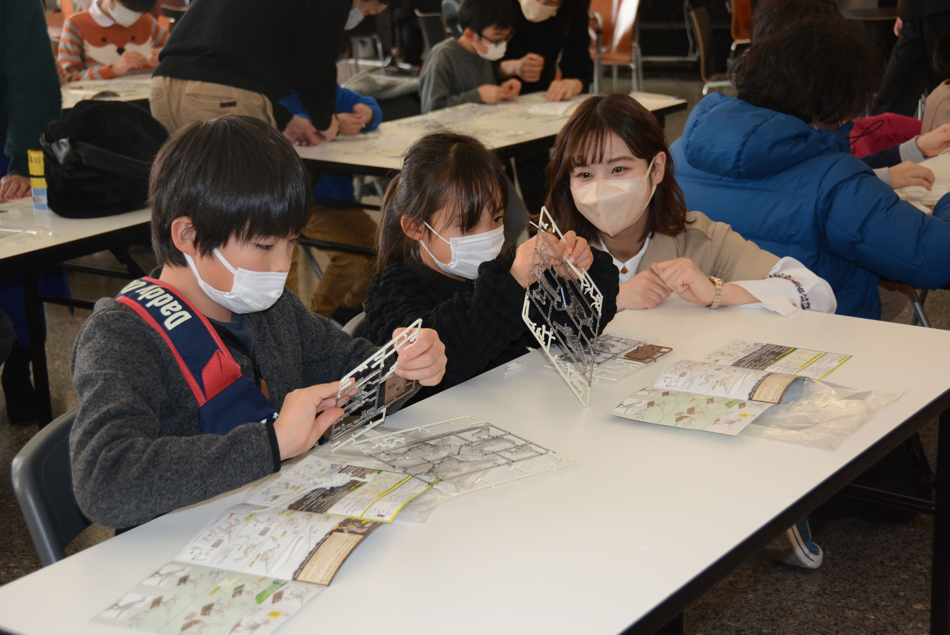 親やゲストの助言を受けながらプラモデルを組み立て