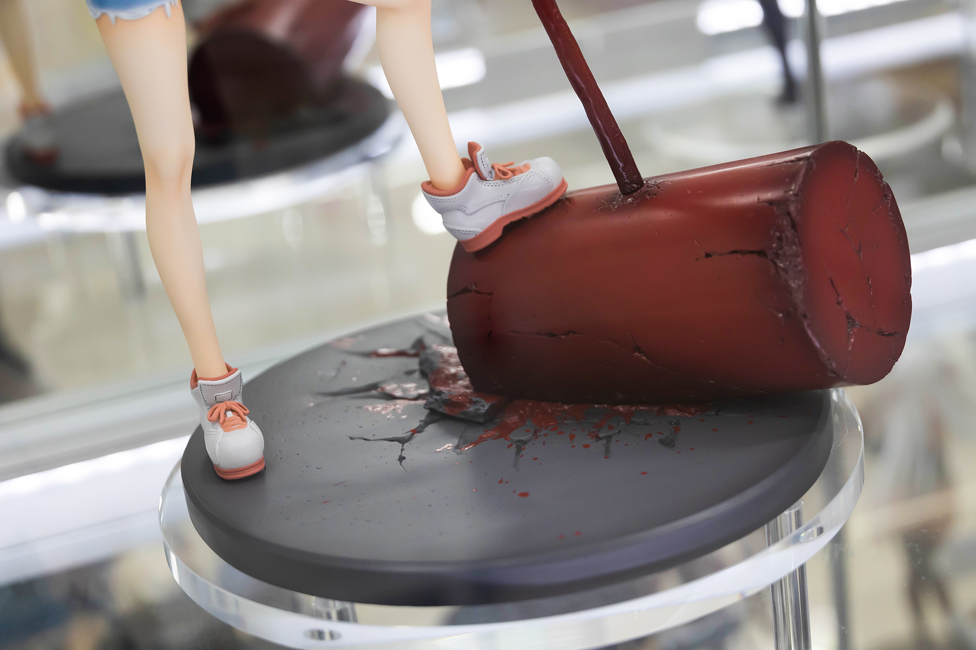 台座部分は、道路のアスファルトに血糊が付いた巨大なハンマーがめり込んでいる