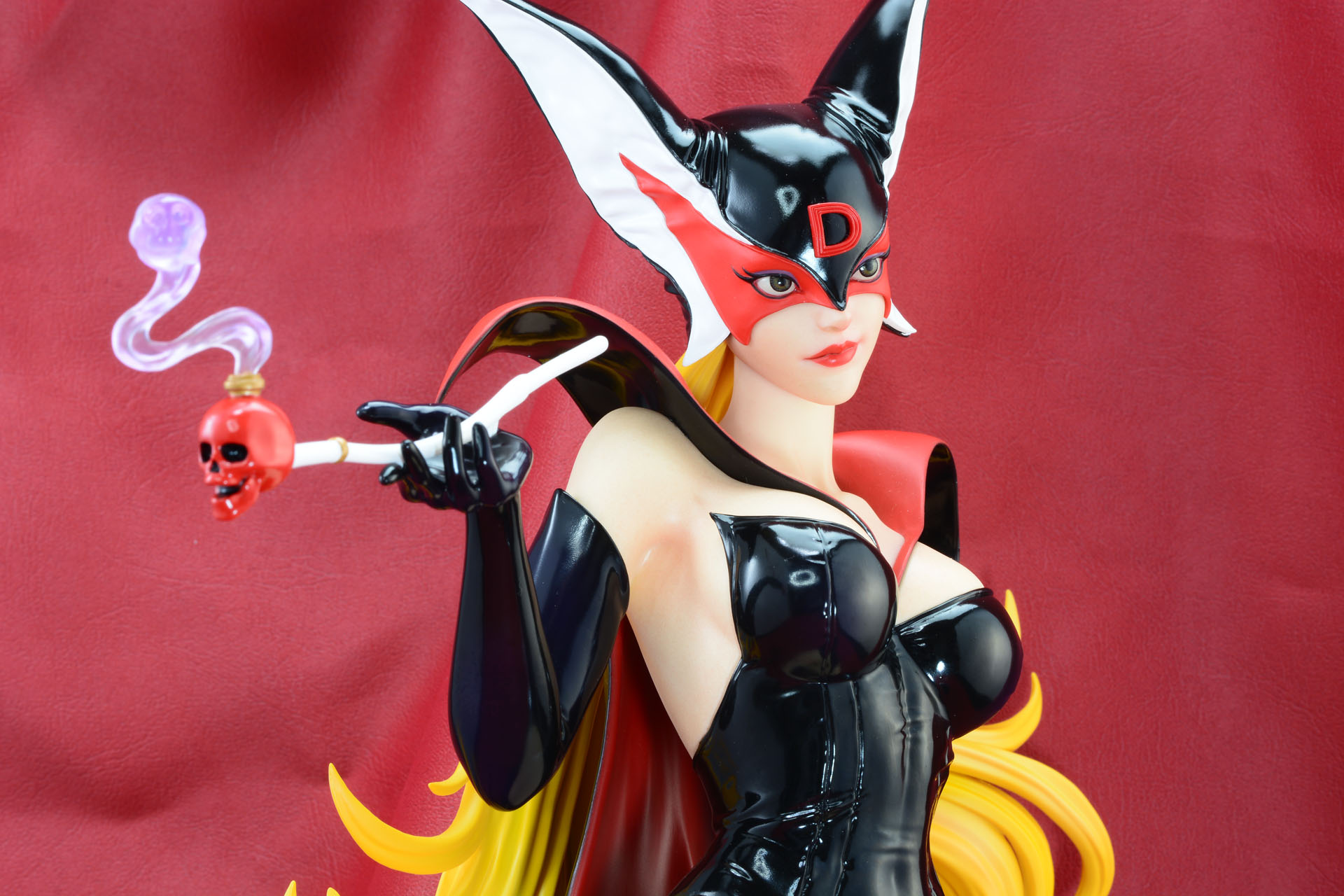 赤いフェイクレザーを背景に。ドロンジョの黒が活きる