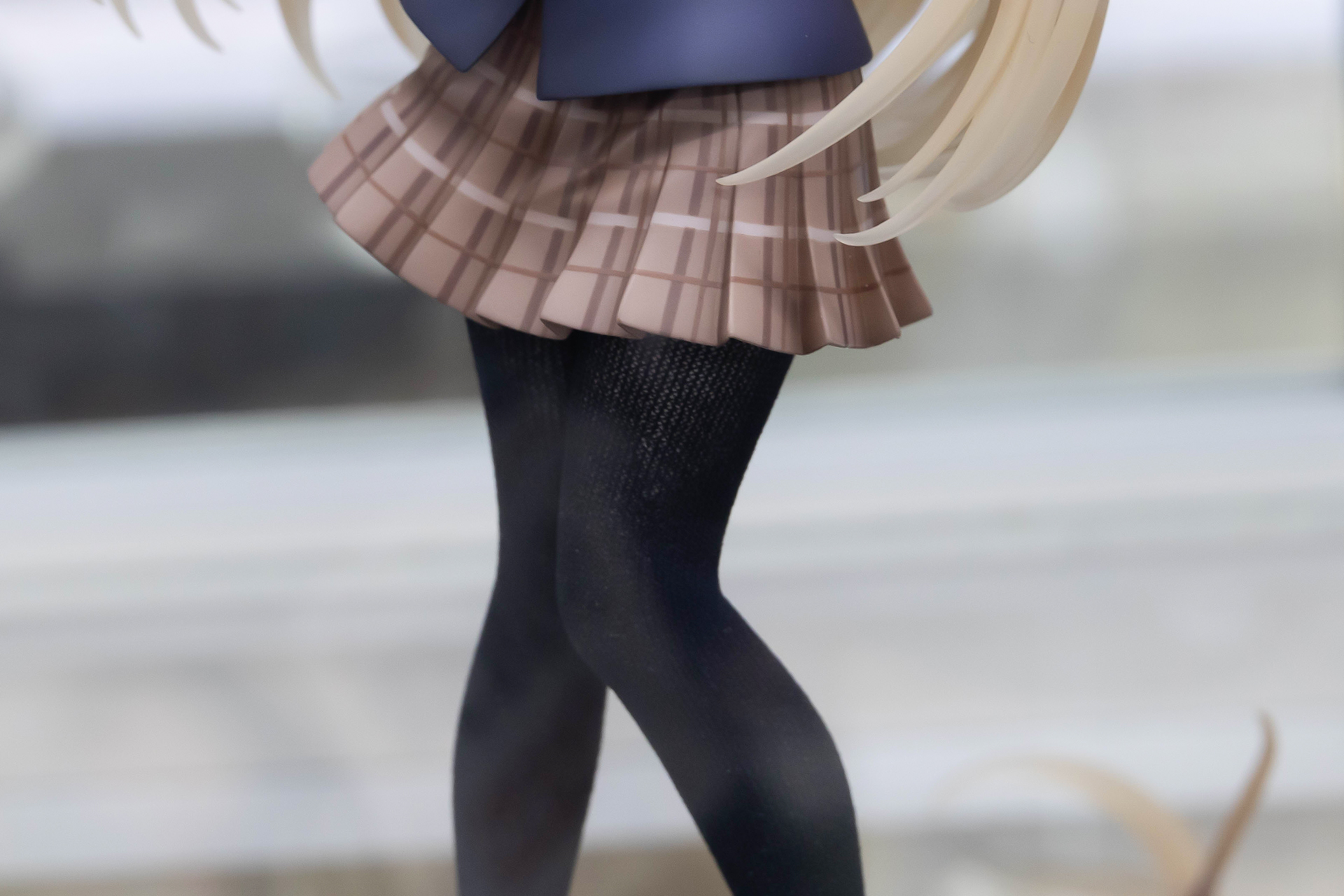 短めの制服のスカートから、黒いストッキングを履いた脚がすらりと伸びている