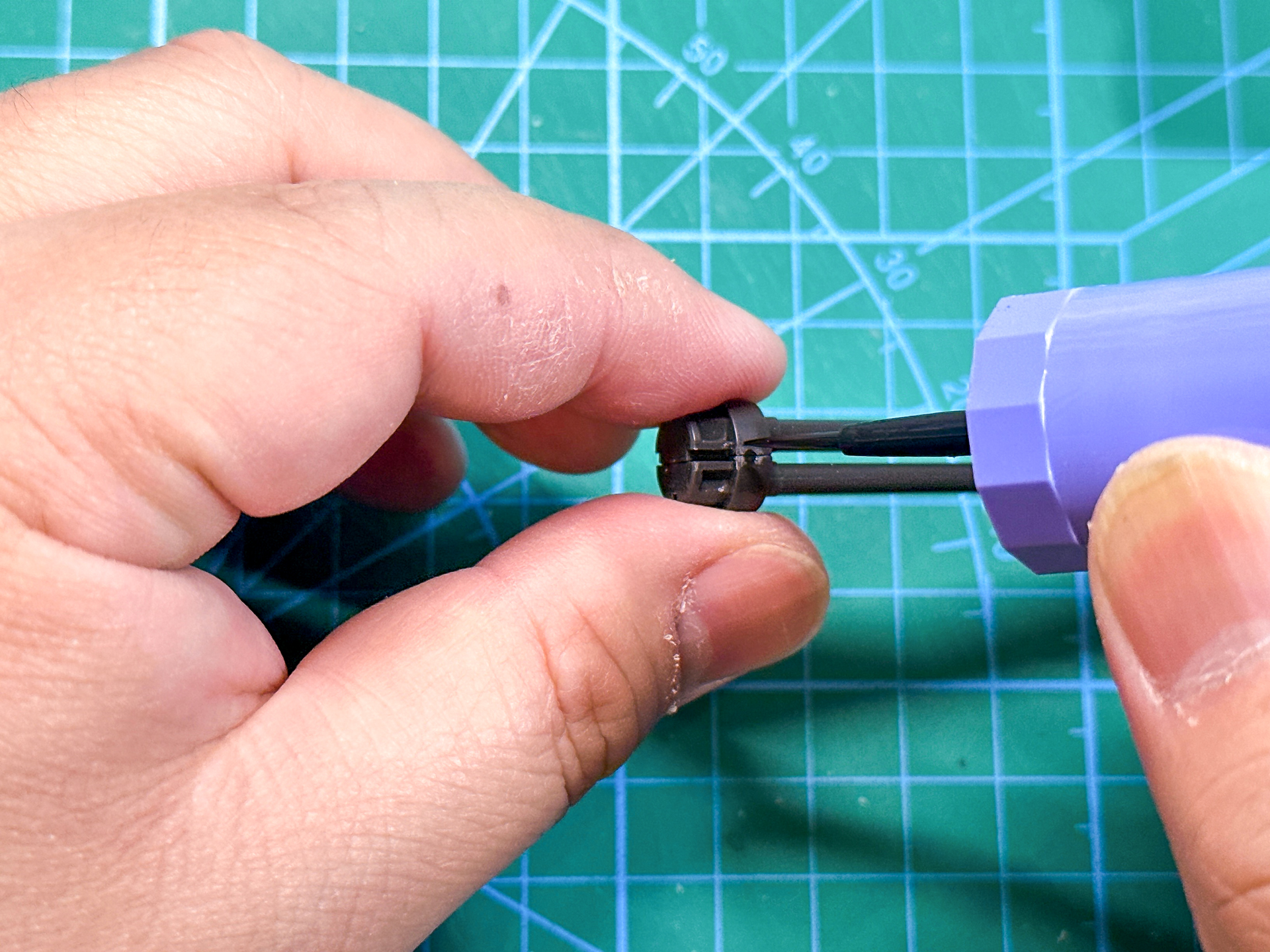 合わせ目消しにはクレオスのMr.セメントSPB（ブラック）を使用していきます。付属の筆を使用して合わせ目に接着剤を流し込んでいきます。