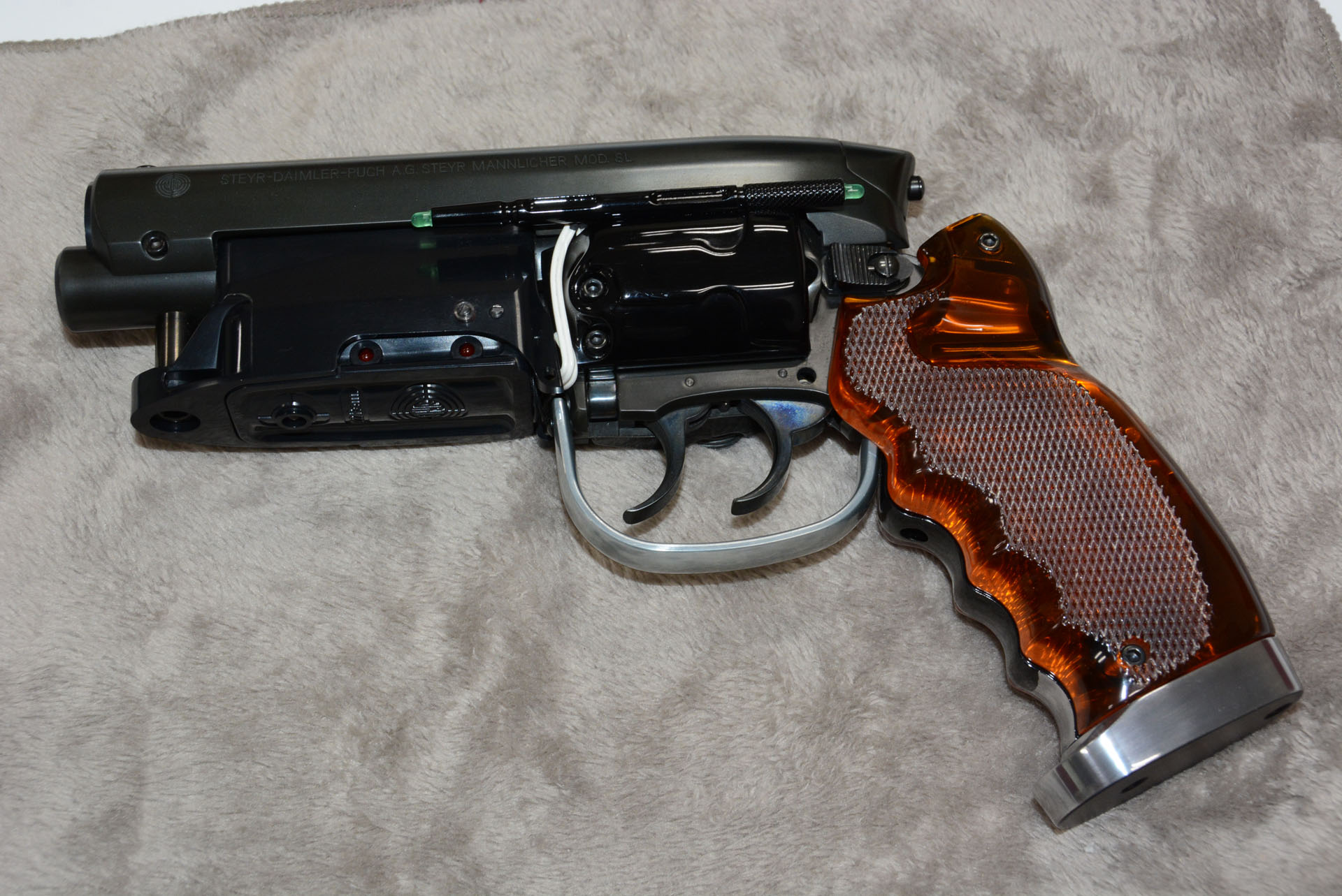 リボルバー型の拳銃に大きなカバー、銃身の下のマガジン、透明の樹脂のグリップ、非常にユニークな形状だ