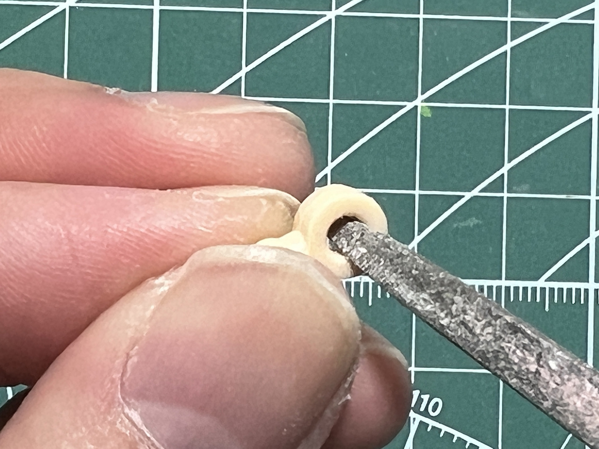 肩の軸穴部分を金属ヤスリで内側を軽く削る。使用しているのはタミヤの「ベーシックヤスリセット (細目ダブルカット)」