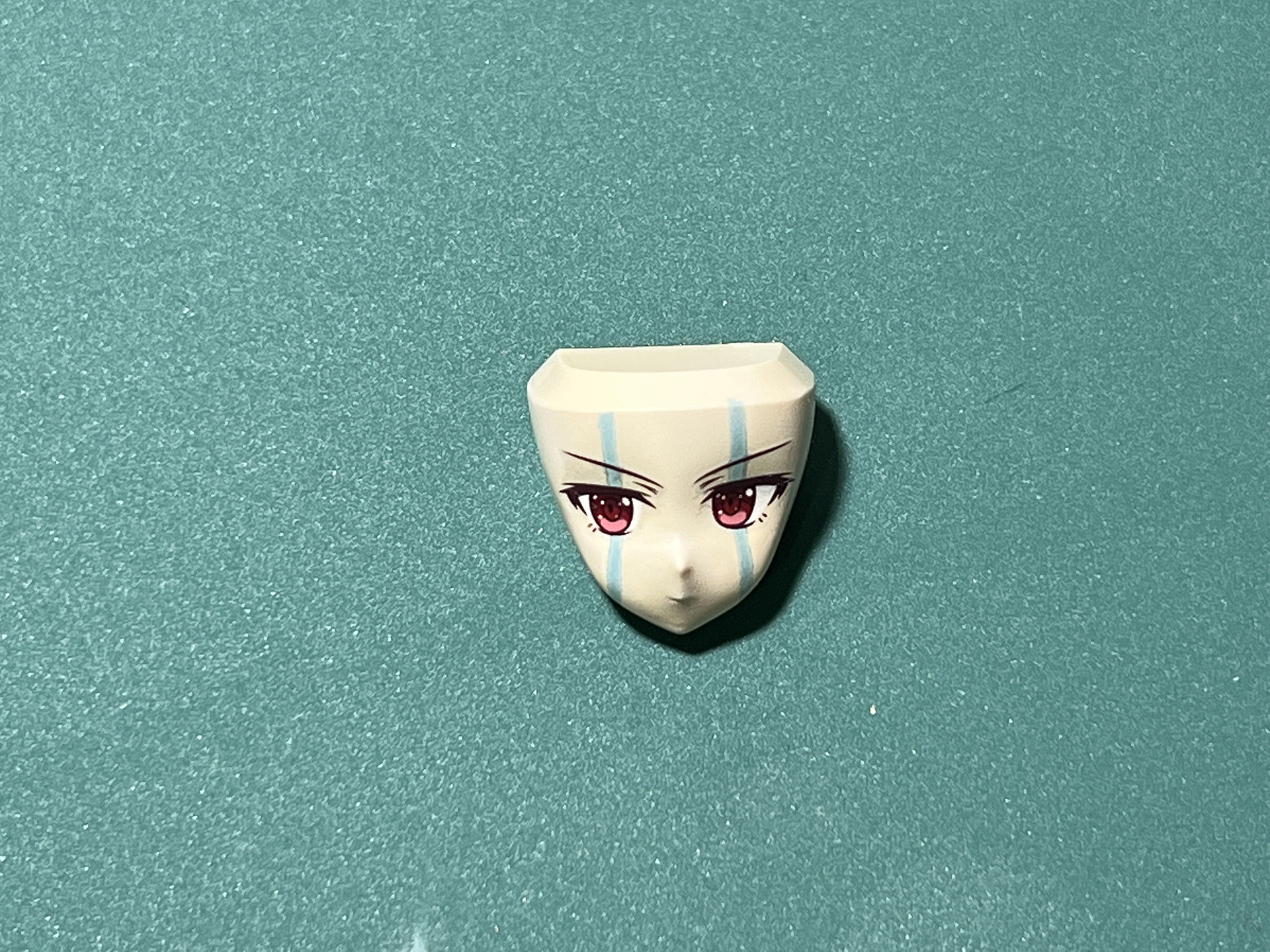 付属の水転写デカールの①を使用。使用するデカールを切り分け、水に浸す。デカールが浮き上がったら、表情パーツに移していく。その際、クレオスの「Mr.マークセッター」を貼る箇所に事前に塗布し、しっかりと貼り付ける。余分な水分は綿棒で拭き取る