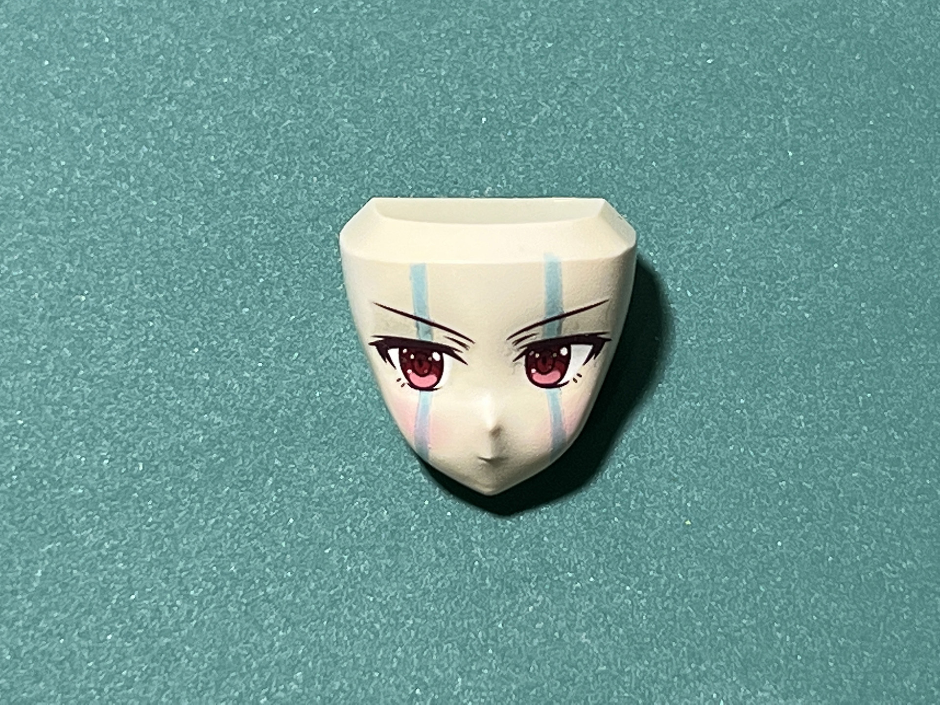 タミヤの「ウェザリングマスター《Ｈセット》」のピーチで頬にチークを入れる。そして、ハイライトとして「サーフェイサー エヴォ ホワイト」、口元は「ココアミルク」で筆塗する