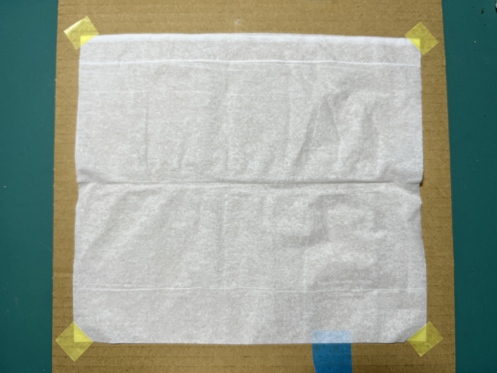 ティッシュペーパーを平たい段ボールに貼り付けて、エアブラシで塗装する。一度では色が出ないので、重ね塗りが必要となる