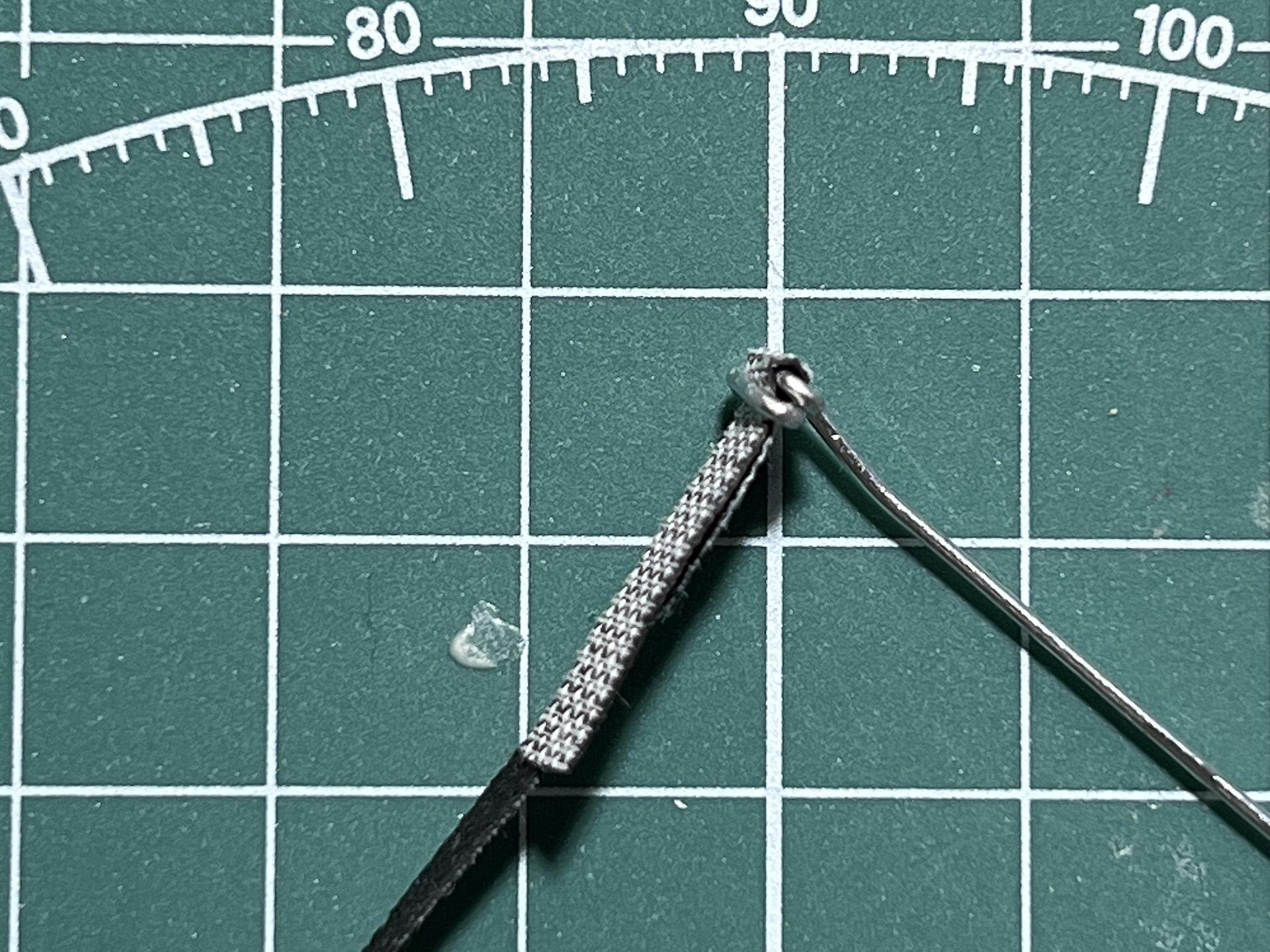 出来上がった弦に合皮のバンドを通す。折り返しでしっかりと固定でき、長さ調整もできる