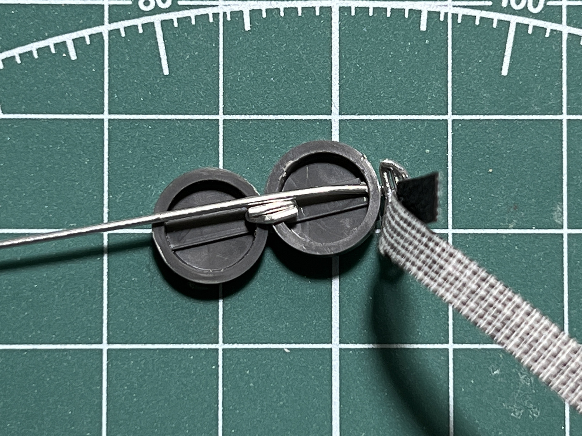 ゴーグルの側面部分に「AL・ライン」を通して、弦を密着させる。そして、折り返して固定し、余剰部部を切る