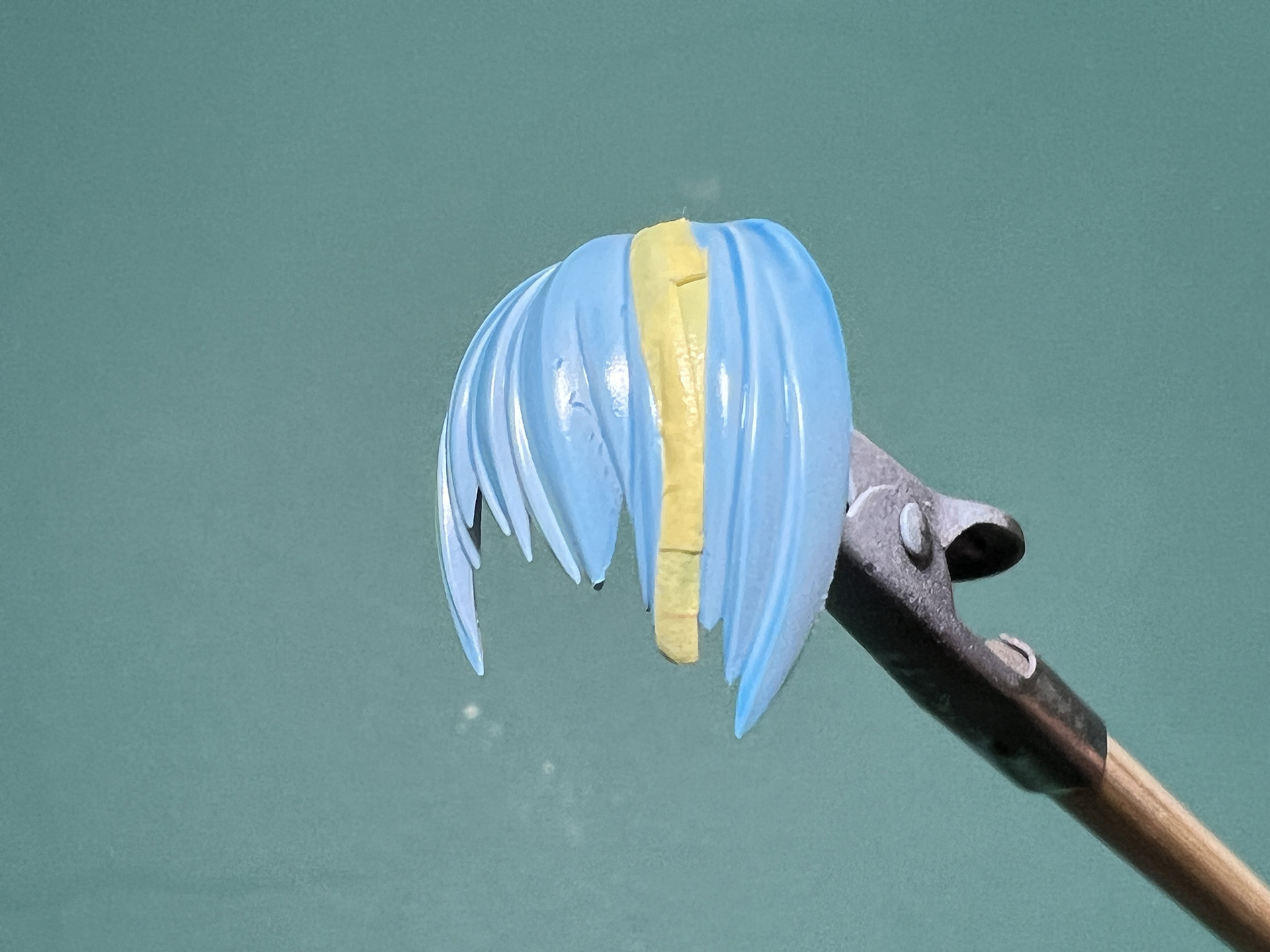 前髪部分はメッシュ表現を入れるためマスキング。「ネイビーブルー」は隠ぺい力があるので、薄く塗り重ねて毛先は残すイメージ