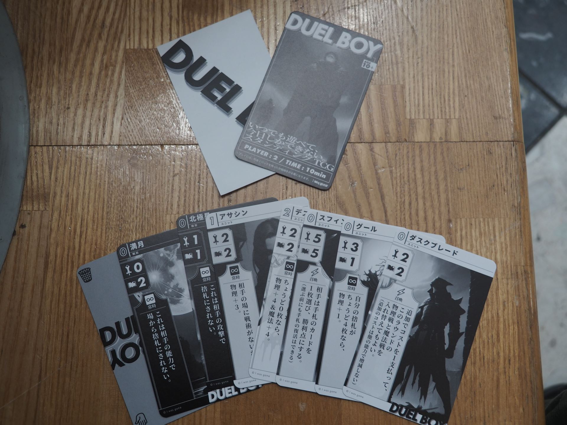 パックの中身、下にある7枚のカード＋仕切り板を使ってバトルを行なう。上の左はステッカーで、これを貼っている人にバトルを申し込む