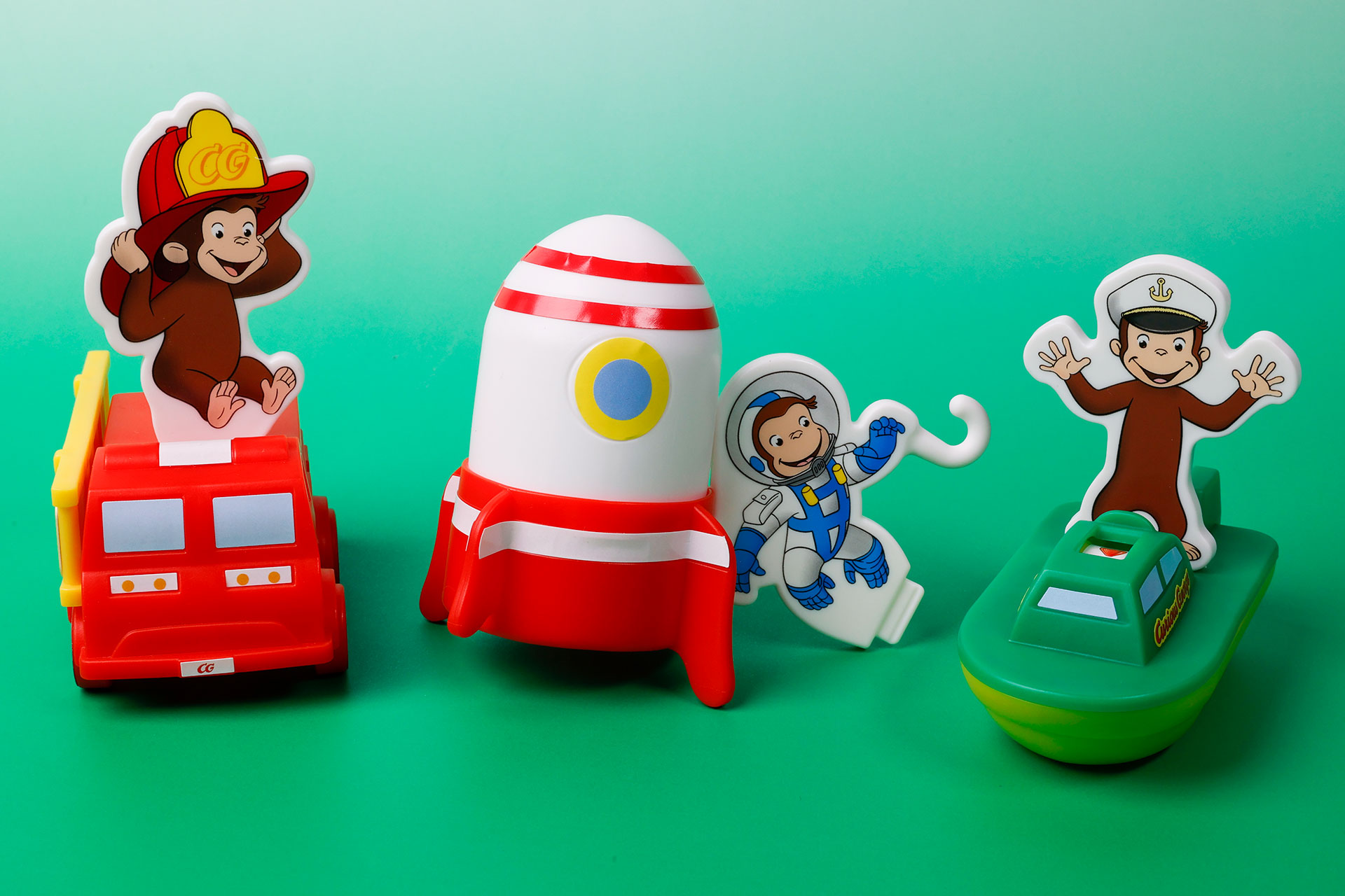 こちらが第1弾（6月16日～6月22日）のハッピーセット「おさるのジョージ」に登場するおもちゃ。写真左から「ジョージのゴーゴー！レスキューしゃ」、「ジョージのうちゅうりょこう」、「ジョージのボートでだいぼうけん」