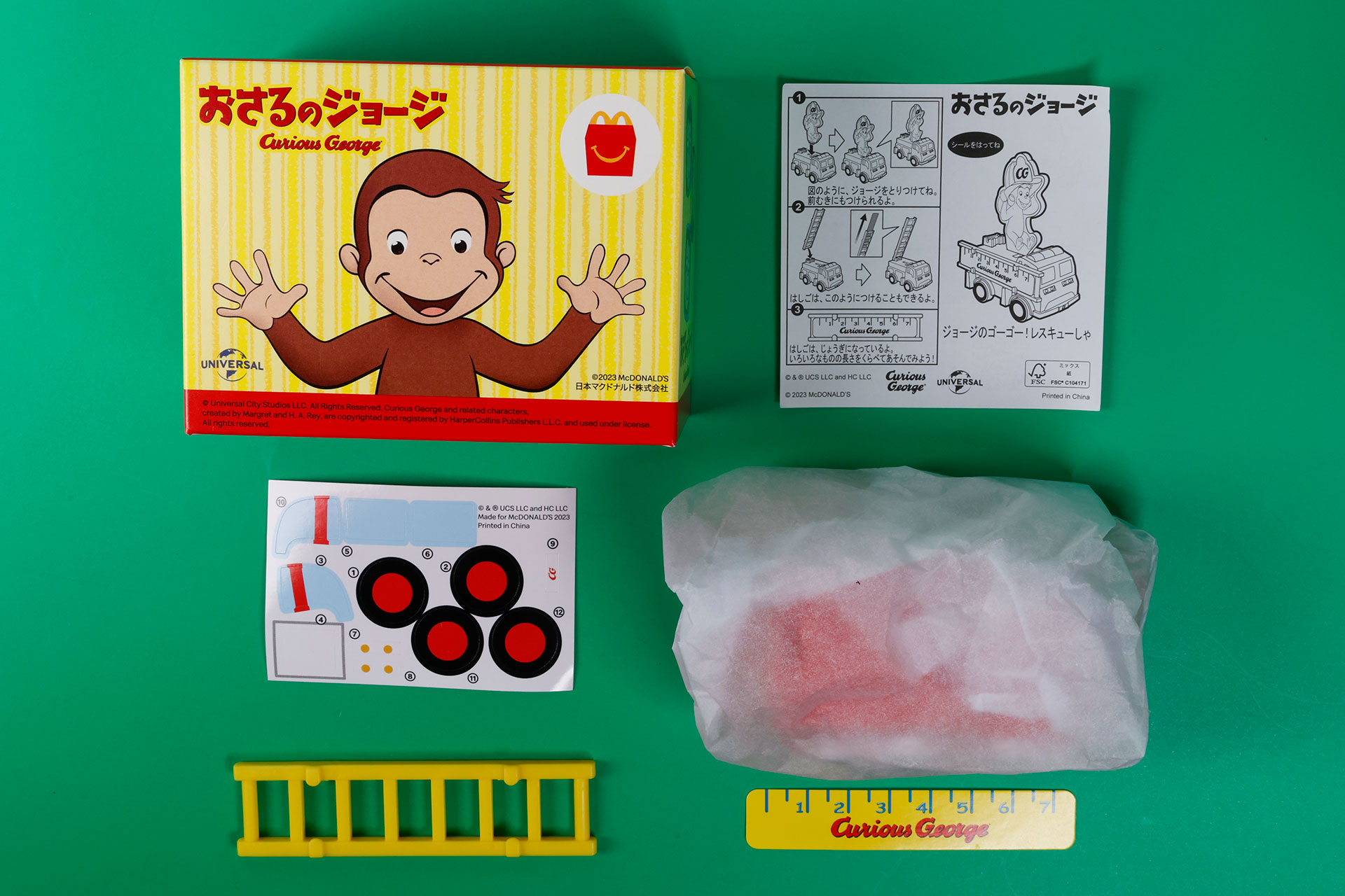 こちらが「ジョージのゴーゴー！レスキューしゃ」のおもちゃ箱の中身。今回のハッピーセット「おさるのジョージ」全体に共通していることだが、おもちゃ本体は和紙のようなものにくるまれて梱包されている