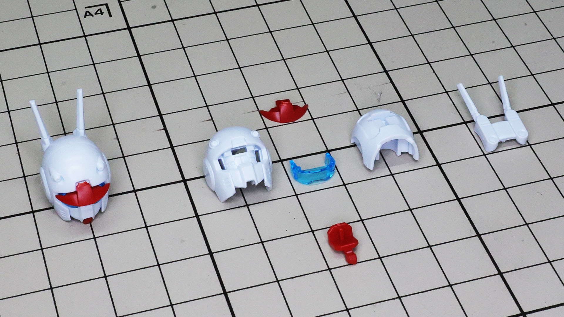 赤いあごのパーツを挟んで、大きな前後のヘルメットを合わせる構造です。左の完成品の赤いひさしが正しく付いていません。この時は原因不明でしたが……