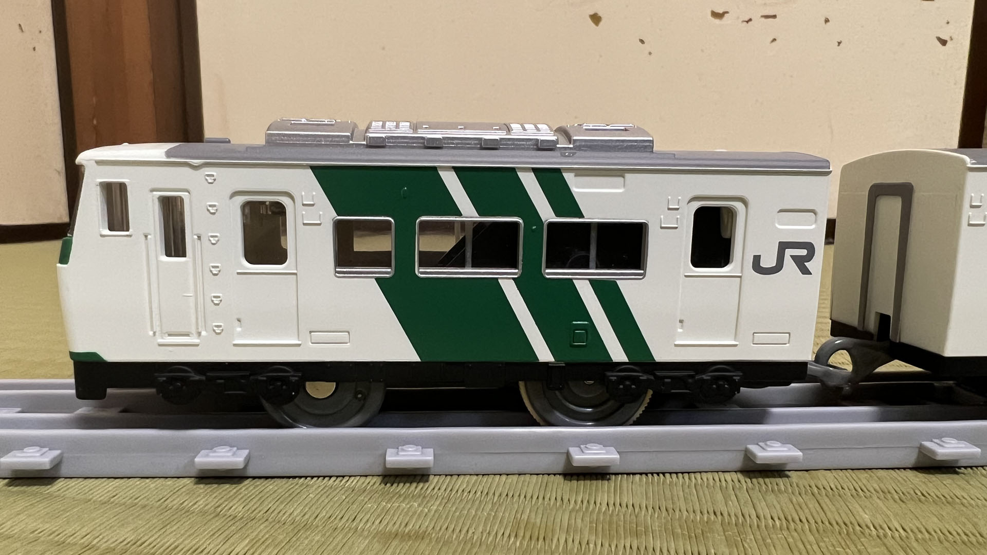 1両目。運転室の窓ガラスが少し奥にあるため、窓の上が庇(ひさし)状になっている。屋根と側壁の間に雨樋がある。運転室扉横の手すりなど造形が細かい。