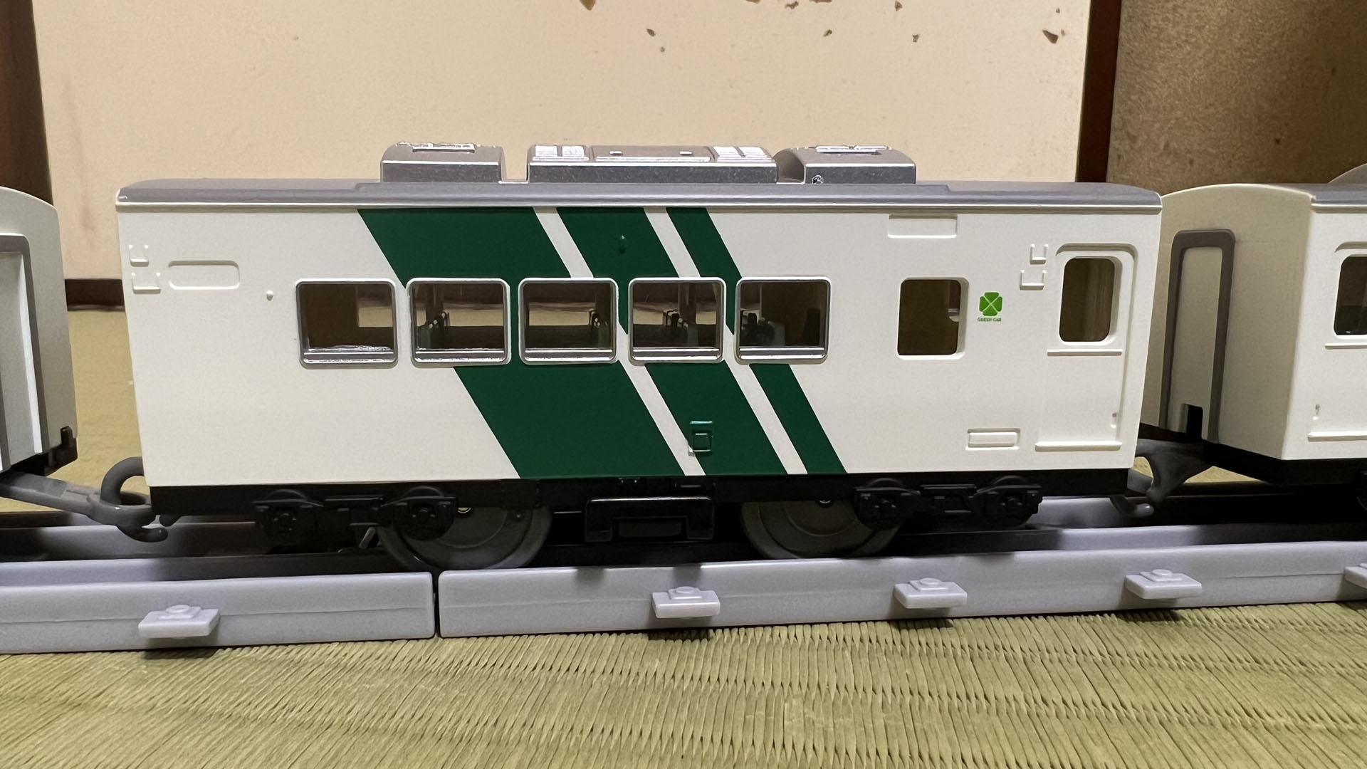 2両目。グリーン車は普通車に比べると窓が小さい。座席一列ごとに窓があるからだ。窓の間もちゃんとストライブが斜めに塗り分けられている。車体側面が丸みをおびているので、平板な乗降扉が奥に引っ込んでいる。外部からドアを操作する装置のカバーなども造形の注目ポイントだ。