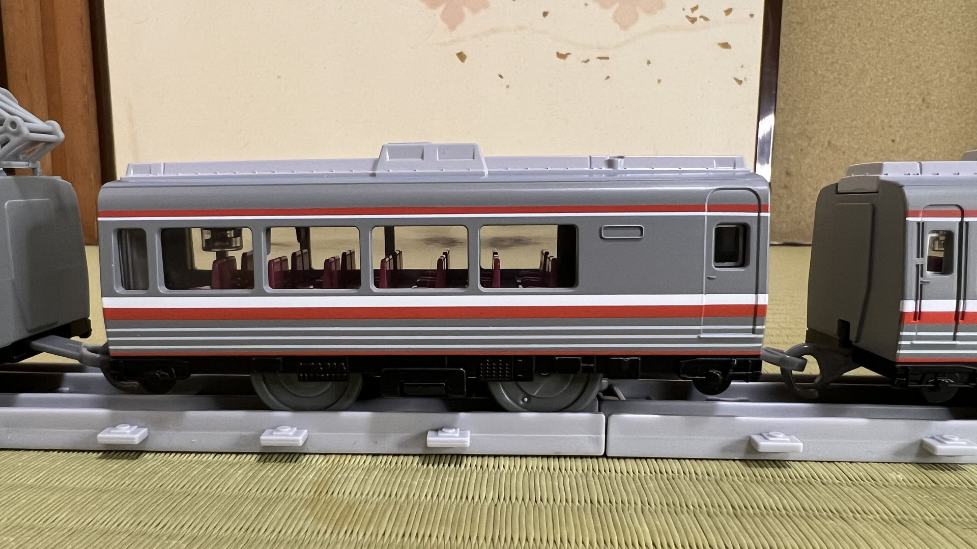 3両目。乗降扉付近に窓がない。屋根のクーラーは前後で対称に見えるけれど、こうして真横からみると造形が異なっている。乗降扉の窓に銀色をあしらうところが細かい