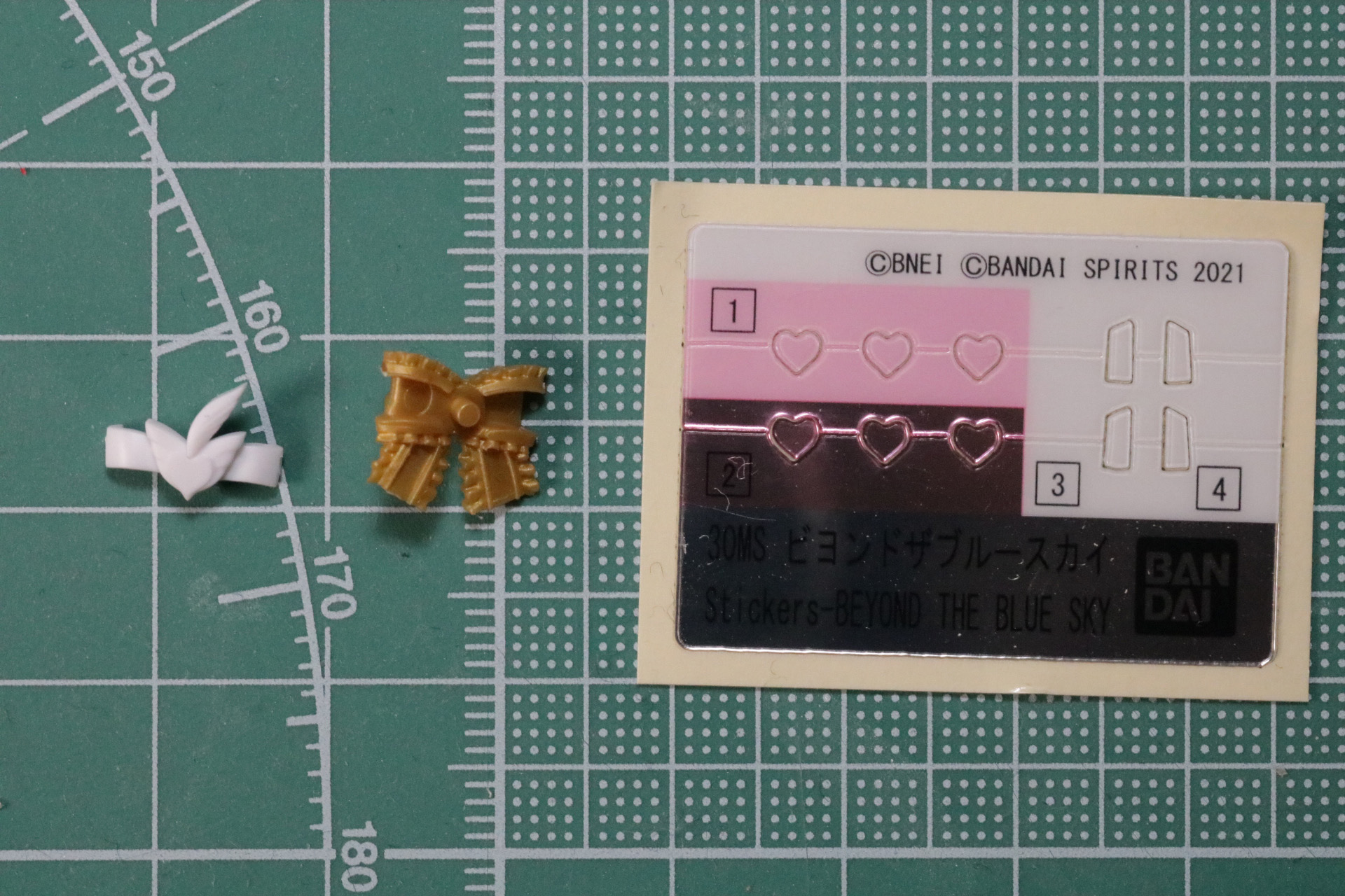 胸元のリボンはプラスチックシールを使用。ハートはナチュラルなピンクときらめくメタリックピンクを選択して貼る