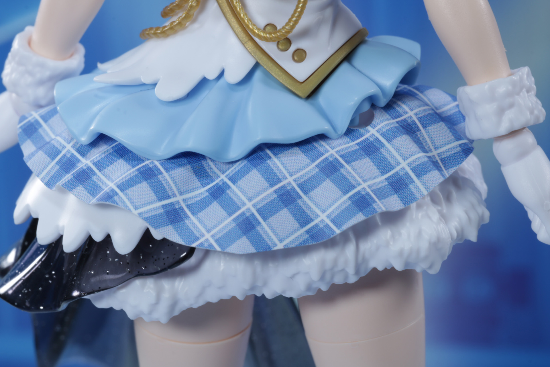 スカートは何層にも分かれ、ボリューム感を演出されている。チェック柄のシートも波打つ造形となっている