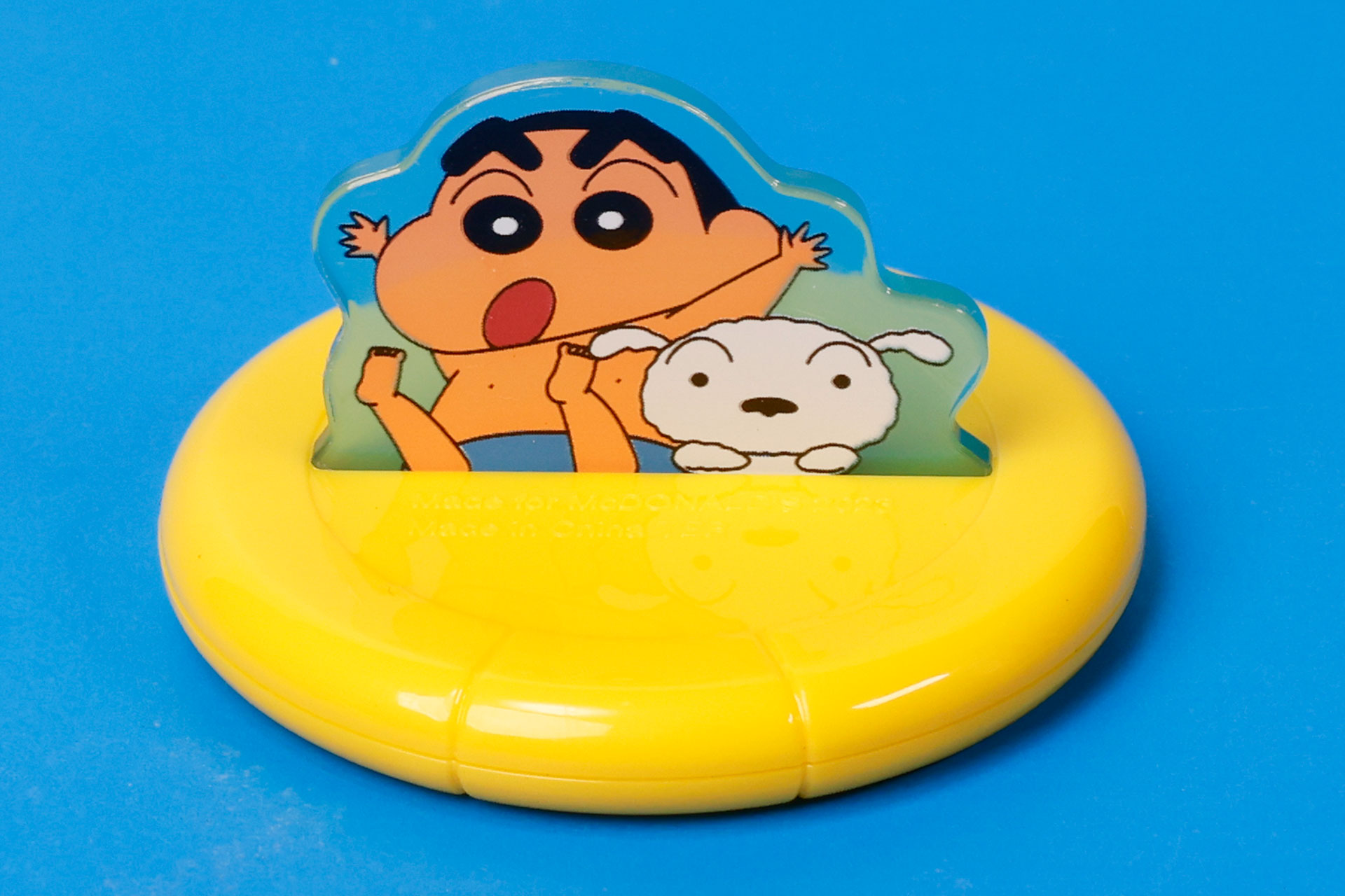 ウォータースライダーのボートのようなものに乗ったしんちゃんとシロ