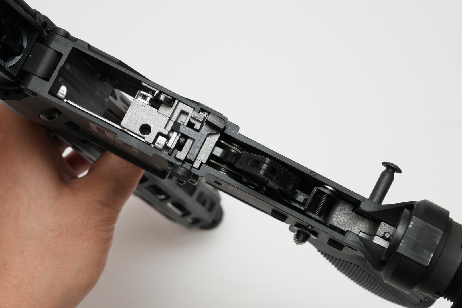 マガジンを抜き、ボルトが閉じている状態でテイクダウンピンを押し込む。チャージングハンドルとボルトを引き抜けば通常分解は完了だ