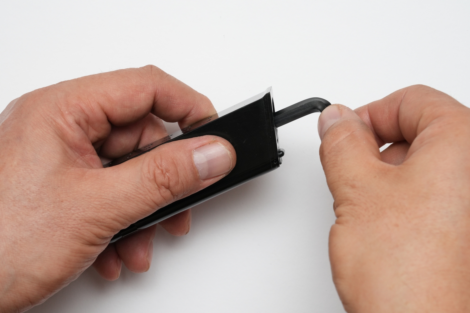 CO2 12gカートリッジを装着するためには、まずはマガジン前面下部のストッパーをずらして、マガジンボトムをスライドして取り外す。その後マガジン底部の円形ベースカバーを取り外してから、CO2 12gカートリッジを挿入する。最後にベースカバーを六角レンチで軽く締め込んで、接触する手応えを感じたら素早く締め込む。締めすぎるとガスケットを傷めてガス漏れの原因となるので要注意